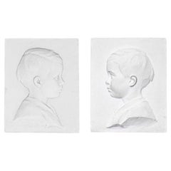 Pareja de perfiles infantiles de escayola, Siglo XX.