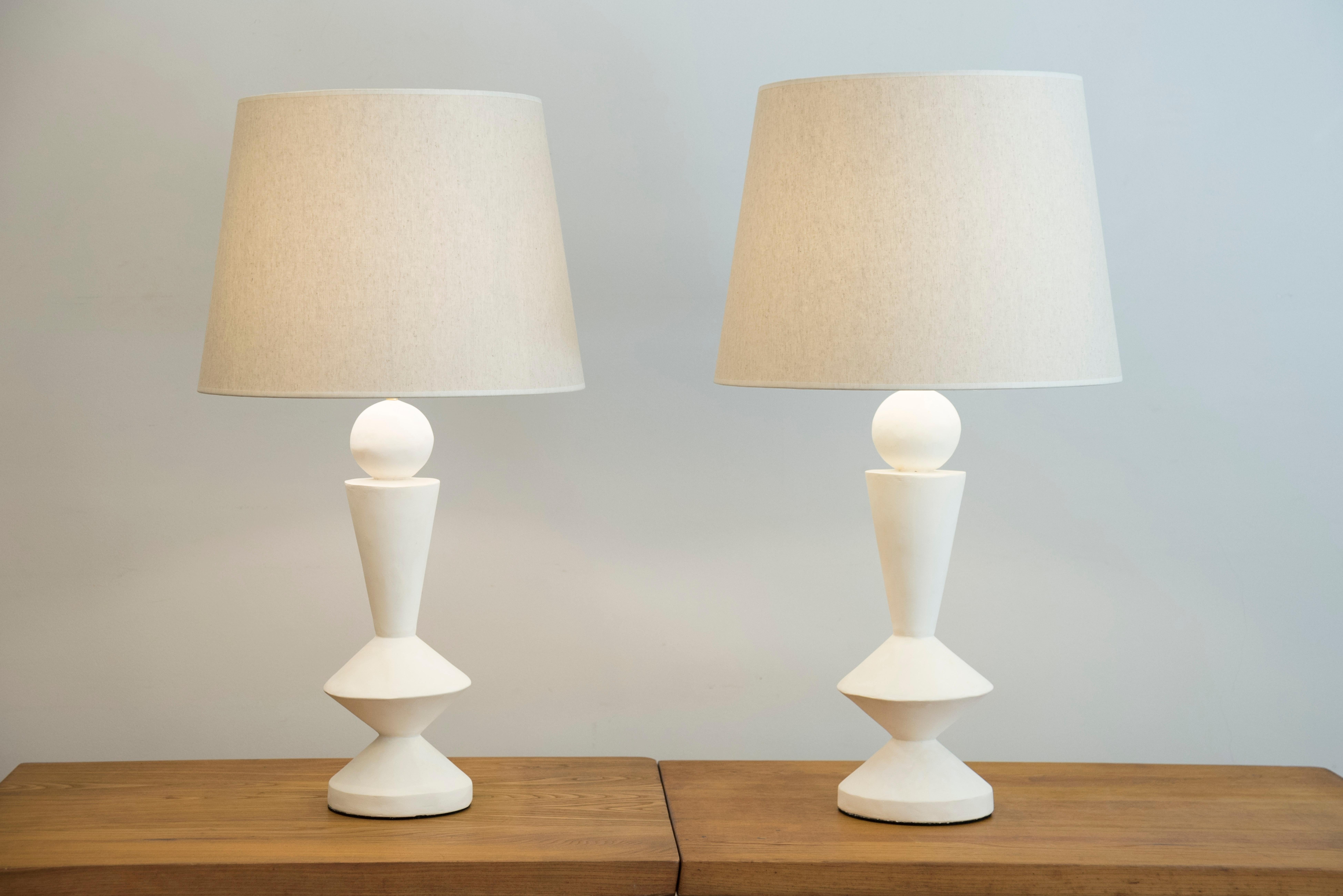 Pair of stuccoed plaster lamps.
Custom made shades.
Inspired by Jean-Michel Frank.
France, modern production.
Model : Diabolo.

Measures: height.
Total 84 cm (33 inches) 
Plaster foot 47 cm (18.5 inches)
Diameter shade 45 cm (17.7 inches).