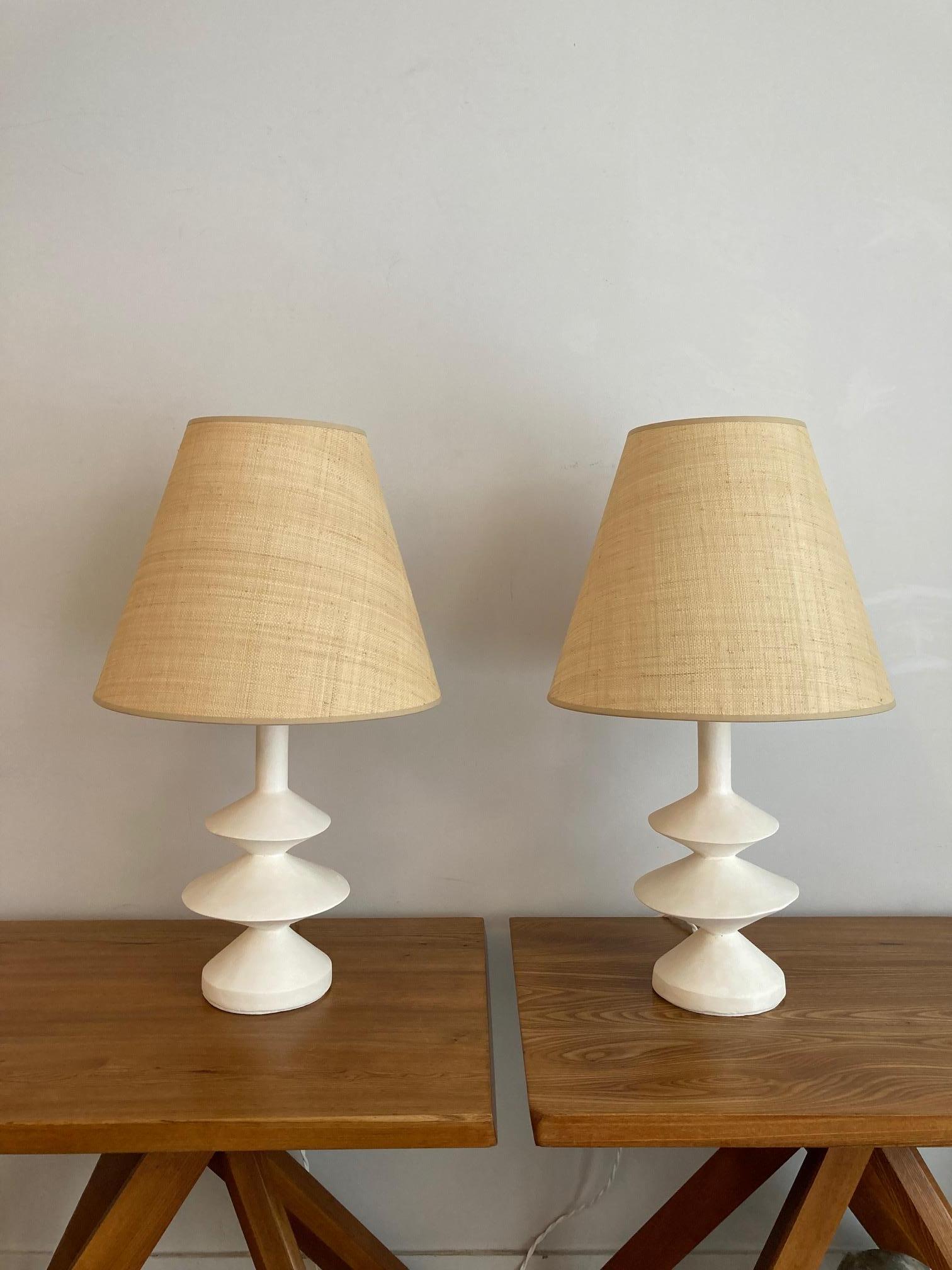 Pair of plaster lamps and custom-made raffia shades
 This production is inspired by the plaster lamp created by Giacometti for Jean-Michel Frank in the 30's.
 French decorator Jacques Grange also designed a plaster lamp inspired by the Giacometti