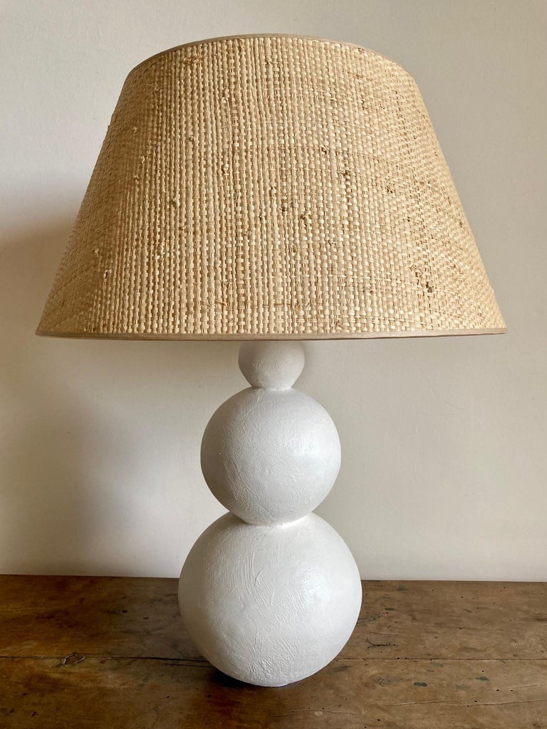 Pair of Art Deco inspired stuccoed plaster lamps.
Custom made raffia shades.
France, modern production
Inspired by the design of ceramic pieces by Primavera.

Measures:
 Height total including shade 58 cm ( 22.8