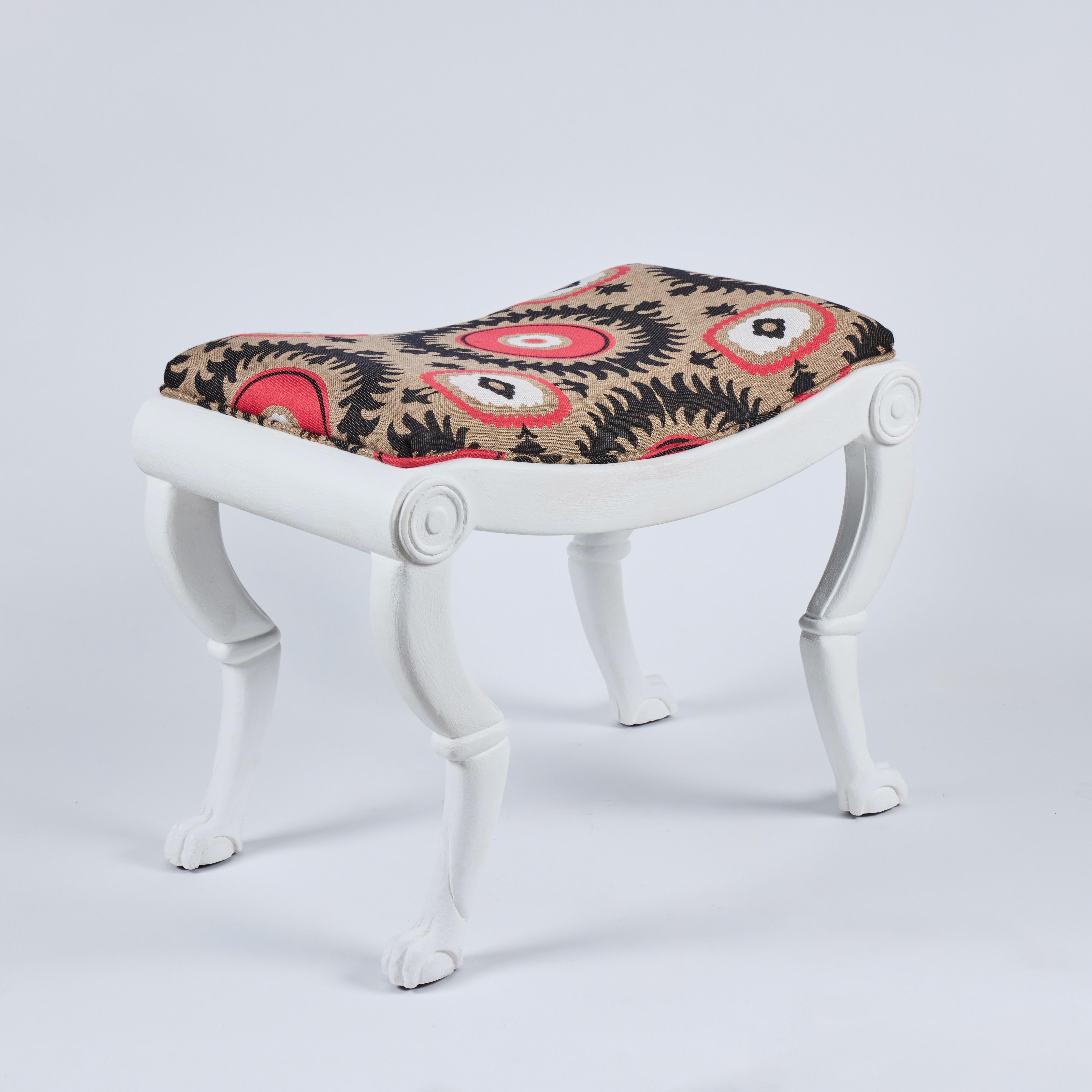Chic pair of carved wood benches with paw feet in white plaster finish.  Newly reupholstered in colorful suzani fabric.  Excellent vintage condition.