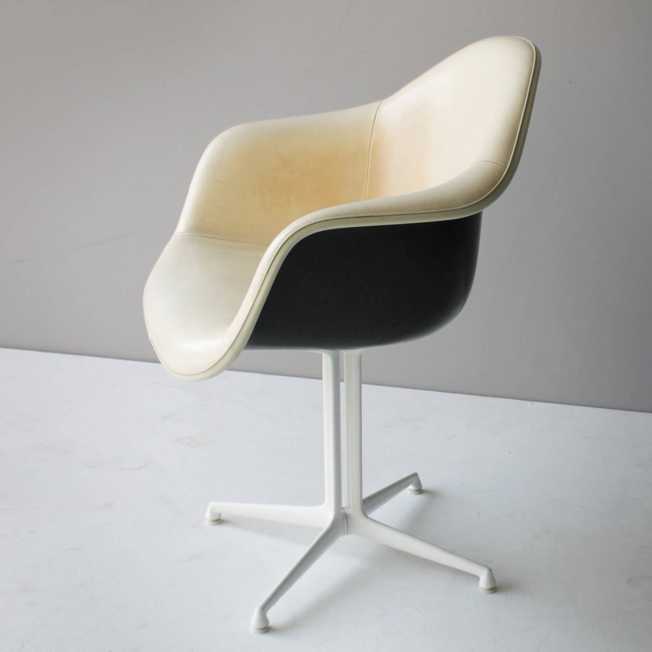 A rare set of two (2) plastic armchairs (DAL) by Charles and Ray Eames with white La Fonda bases. Herman Miller production for Fehlbaum, marked. Period 1960-1965.
Black fibreglass shell with ivory colored naugahyde vinyl upholstery. Cast aluminum