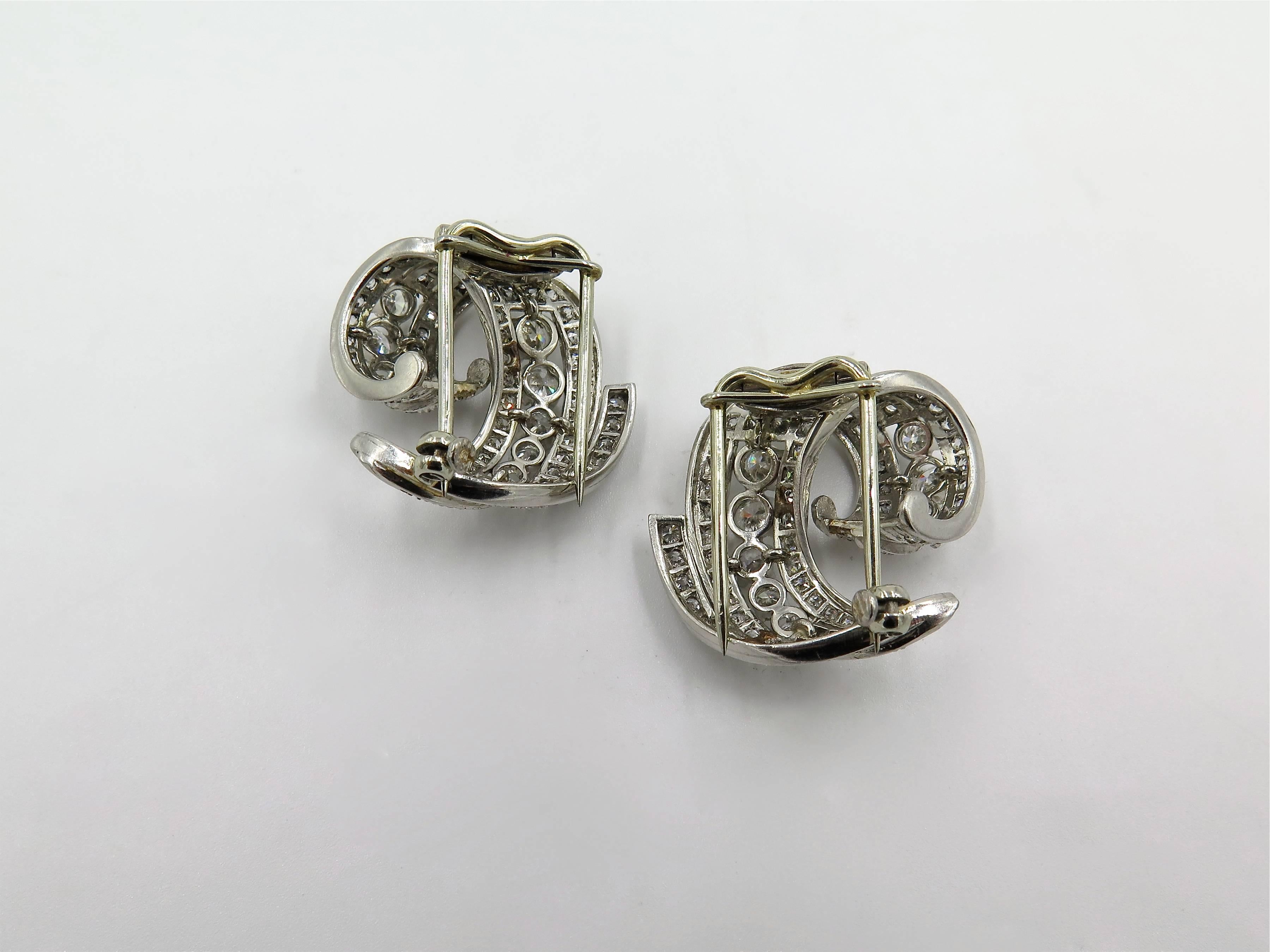 A pair of platinum and diamond brooches. Circa 1950. Each of scrolling design, set with circular and pave set diamonds. One hundred and forty six diamond weigh approximately 3.40 carats total. Length is approximately 1 inch. Gross weight is