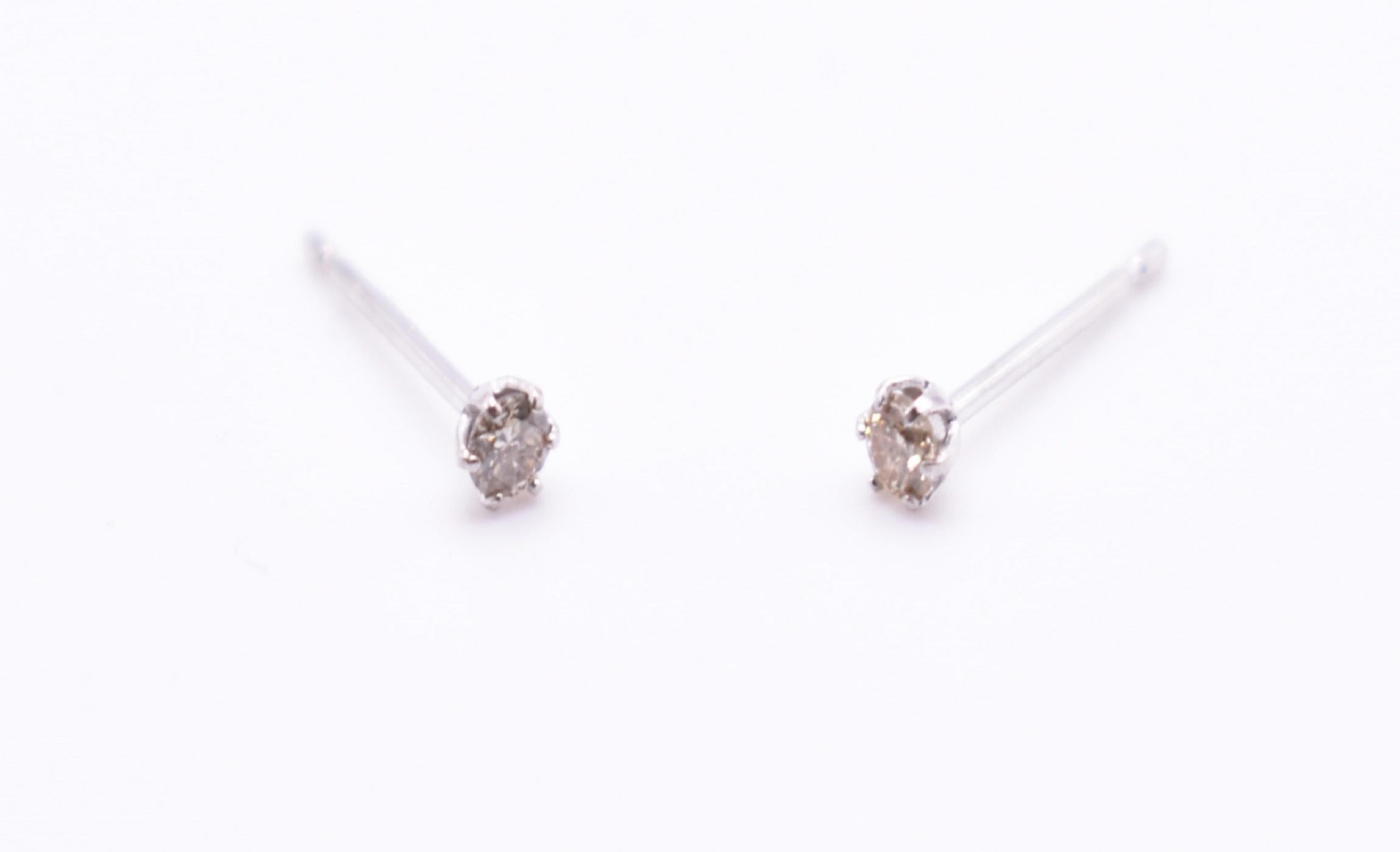 A pair of small platinum diamond stud earrings. PT 900 Platinum = 0.22G Diamonds = 0.10ct