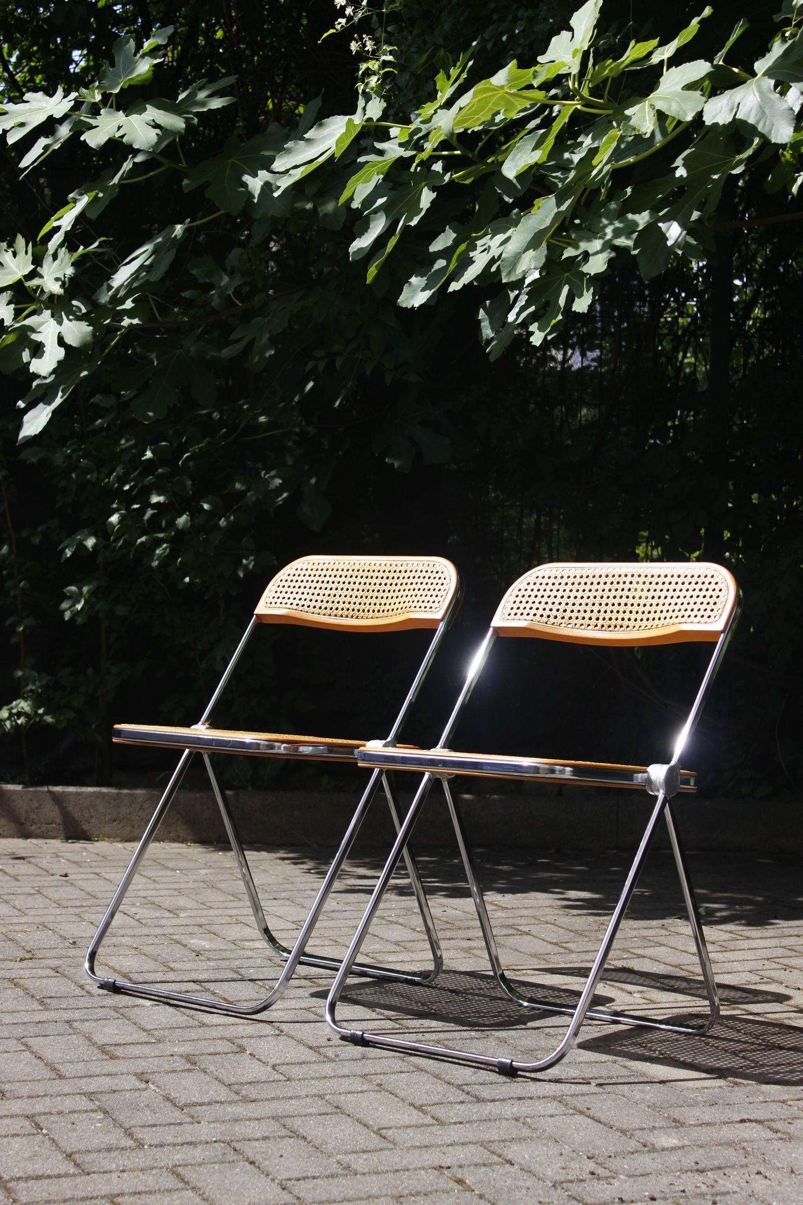 Pair of Plia folding chairs designed by Giancarlo Piretti for Castelli, Italy, circa 1970.

Uncommon model with cane seat and backrest.

Both in very good condition, no defects to note in the cane work, chrome not oxidized.