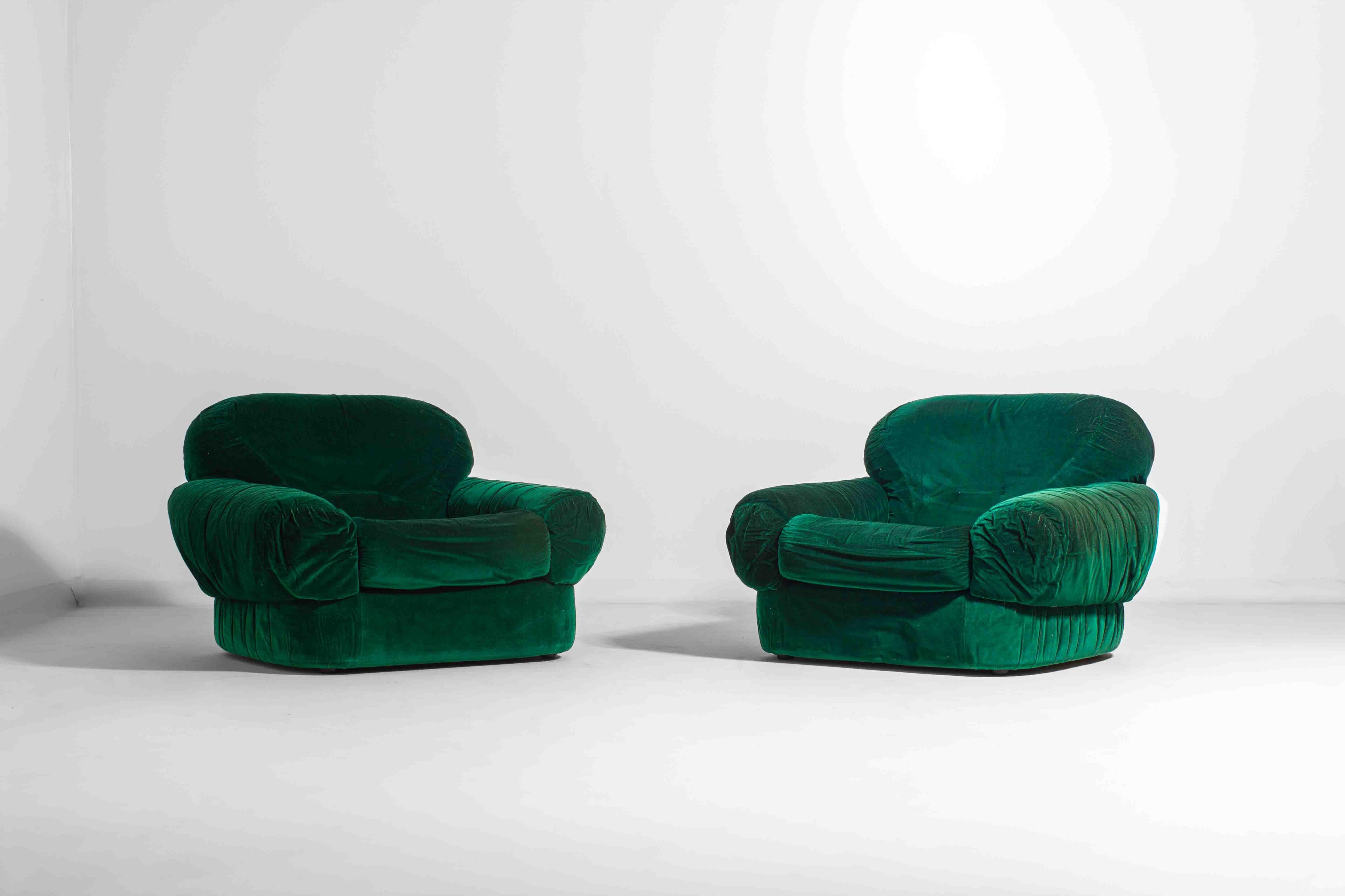 This pair of Italian lounge fauteuils stands out with their deep green velvet upholstery and plush, oversized cushions. The soft, rounded shape and generously padded armrests make them perfect for relaxing for many hours at a time. Their bold color