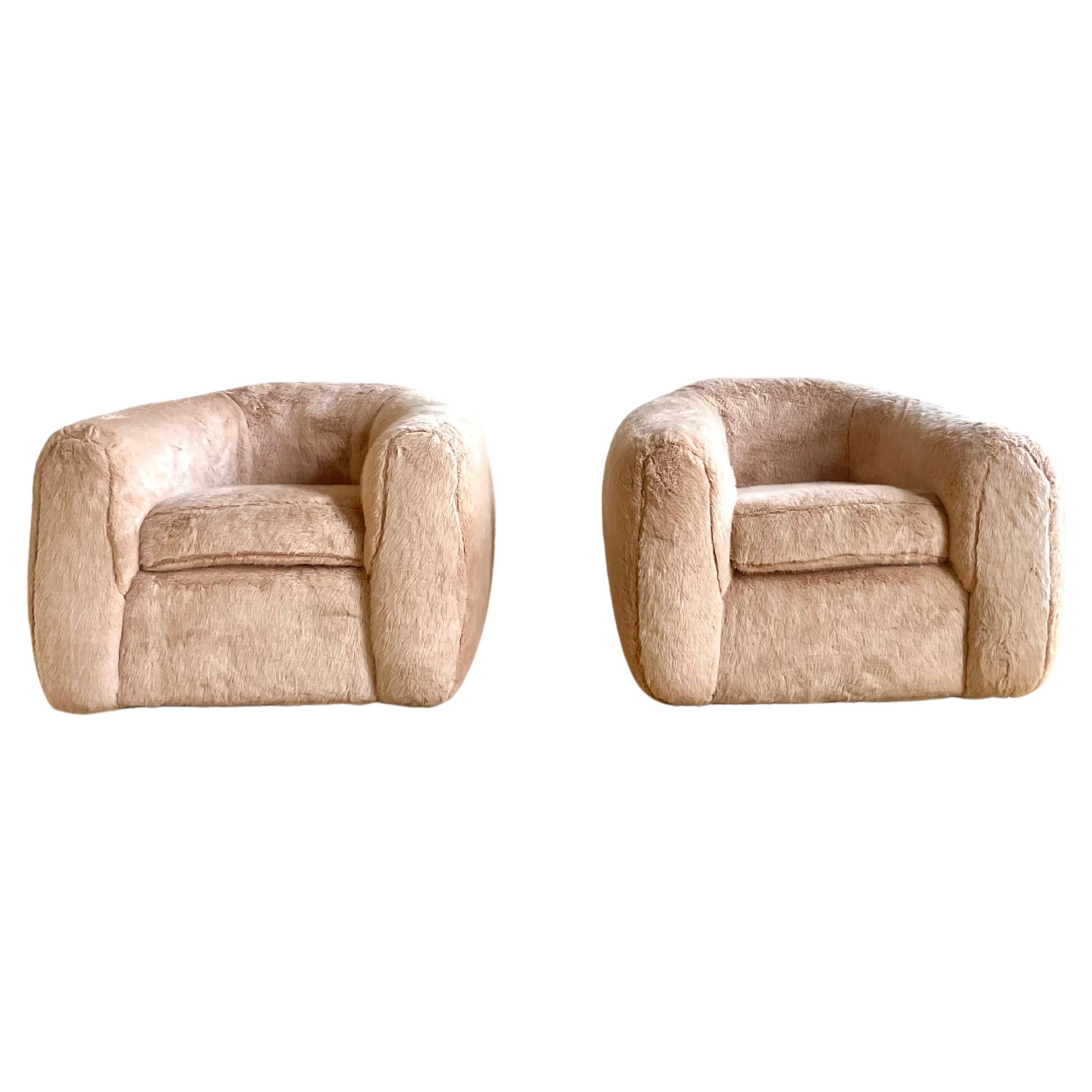 Absolutely stunning pair of Jean Royere style chairs in light pink faux fur.

The chairs are extremely comfortable with a unique profile hiding 4 wood legs. 

These chairs were custom made for a sophisticated Manhattan penthouse.

Chairs do not