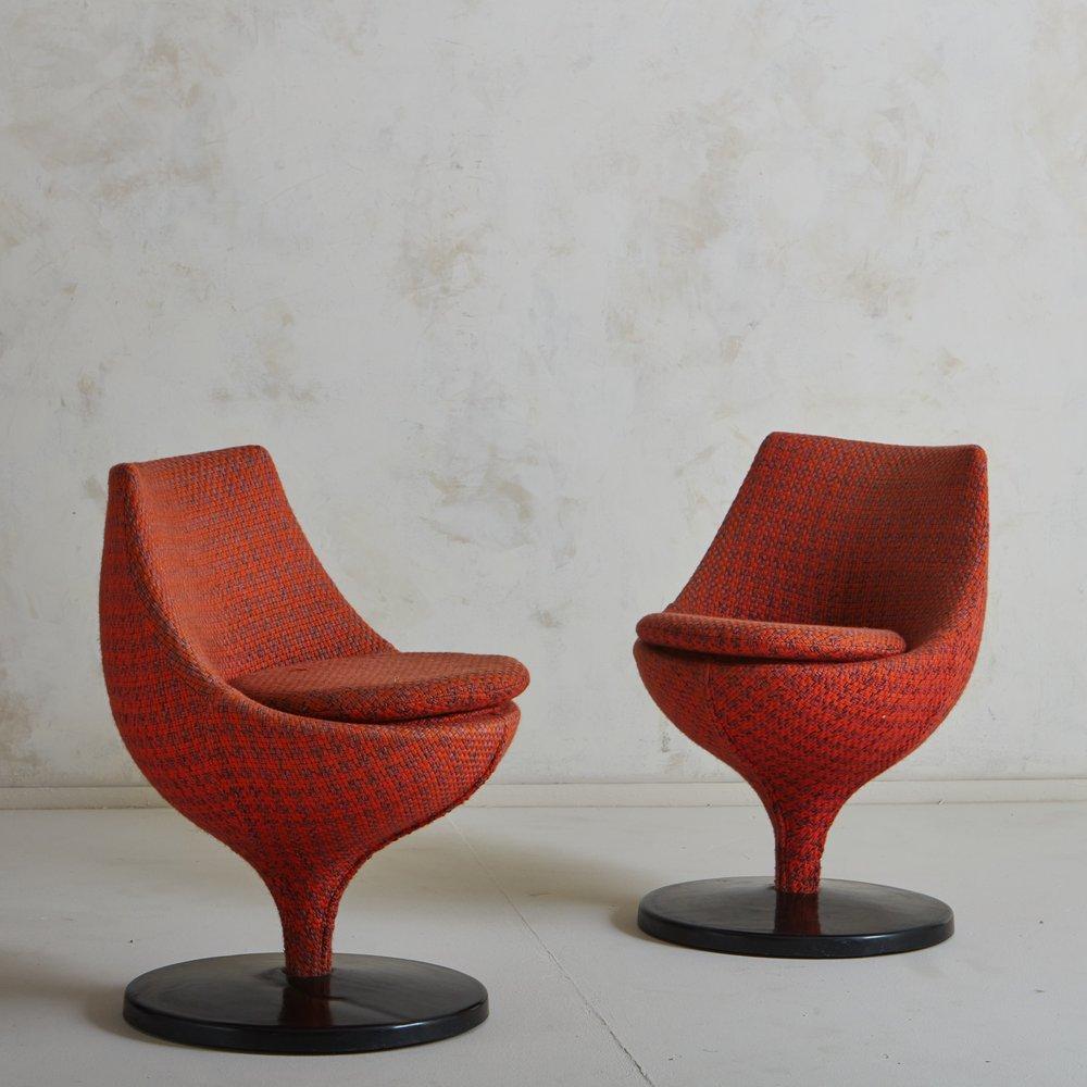 A pair of Polaris chairs designed by Pierre Guariche for Meurop in the 1950s. These chairs feature curved tulip frames and have metal swivel bases with black acrylic covers. They have removable circular cushions and retain their original red and