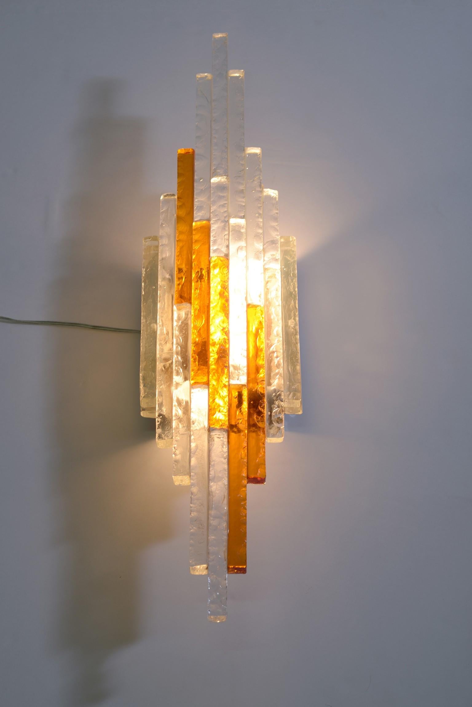 Poliarte 1960s Italian double color, transparent and amber color step degrading chiselled glass wall light -sconces, three little Edison bulbs in a metal structure ich sconce, huge dimensions.
Poliarte Italia midcentury.