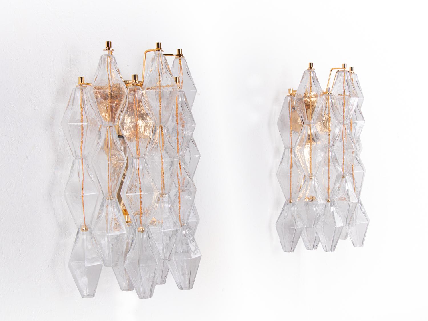 Elegant vintage pair of wall sconces with clear handblown Murano Poliedri glass elements on a gold plated frame. Designed by Carlo Scarpa for Venini, manufactured in Italy. 

Colors: white, clear and golden. 
Measures: dm 11.8