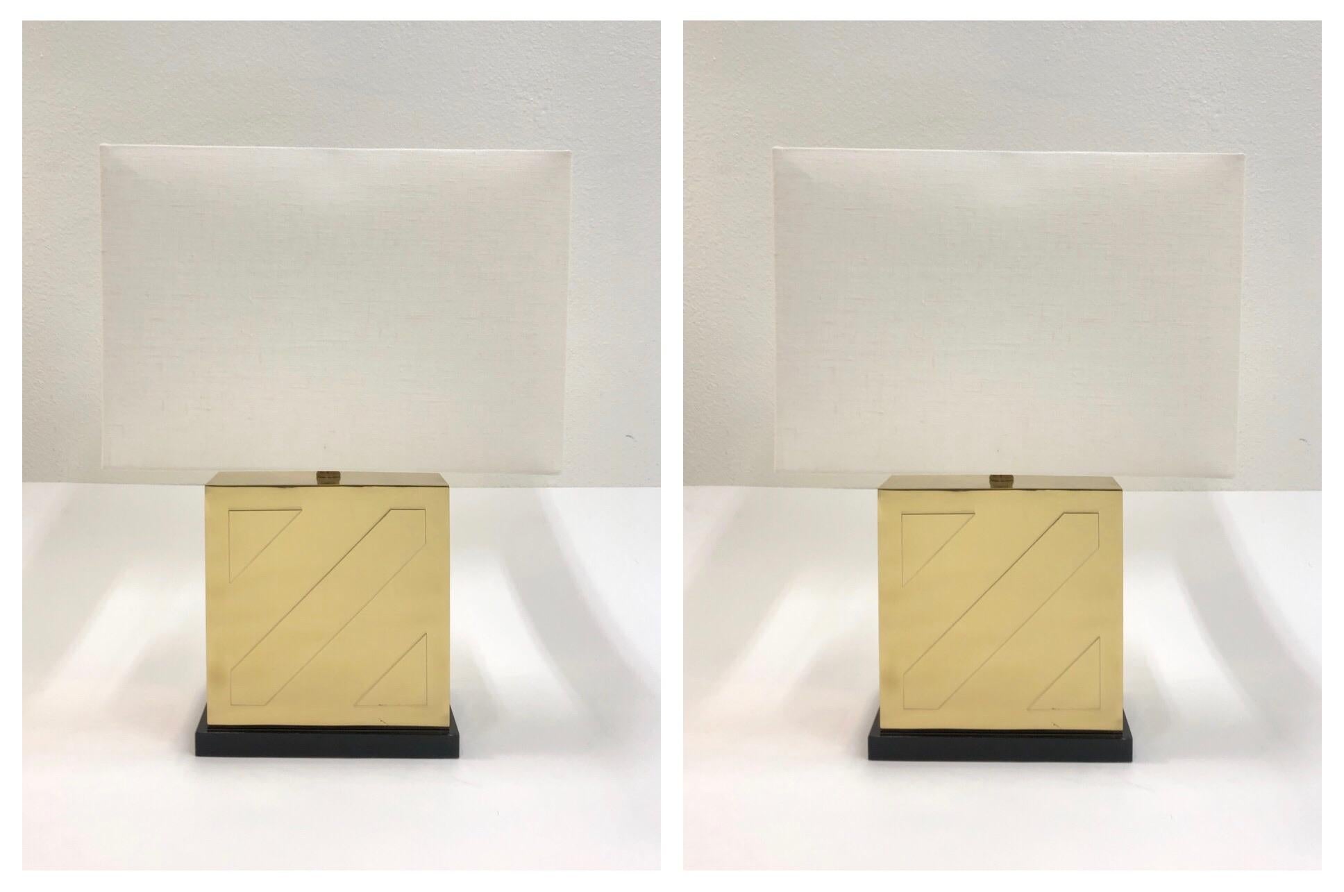 A glamorous pair of table lamps by Chapman Lighting from the 1970s. The lamps are constructed of polished brass, black lacquer bases and new vanilla linen shade. 
Newly rewired with new hardware. 
Dim: 16” wide 16” deep 23.5” high.