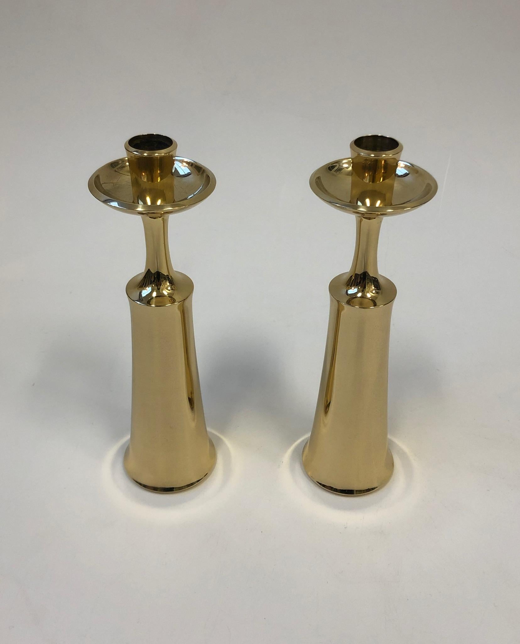 A beautiful pair of solid polish brass candlesticks design by Jens Quistgaard for Dansk in the 1950s. Newly professionally polish and lacquered. The candlesticks are signed (see detail photos). Each candleholder measures: 9.5” high and 2.75”