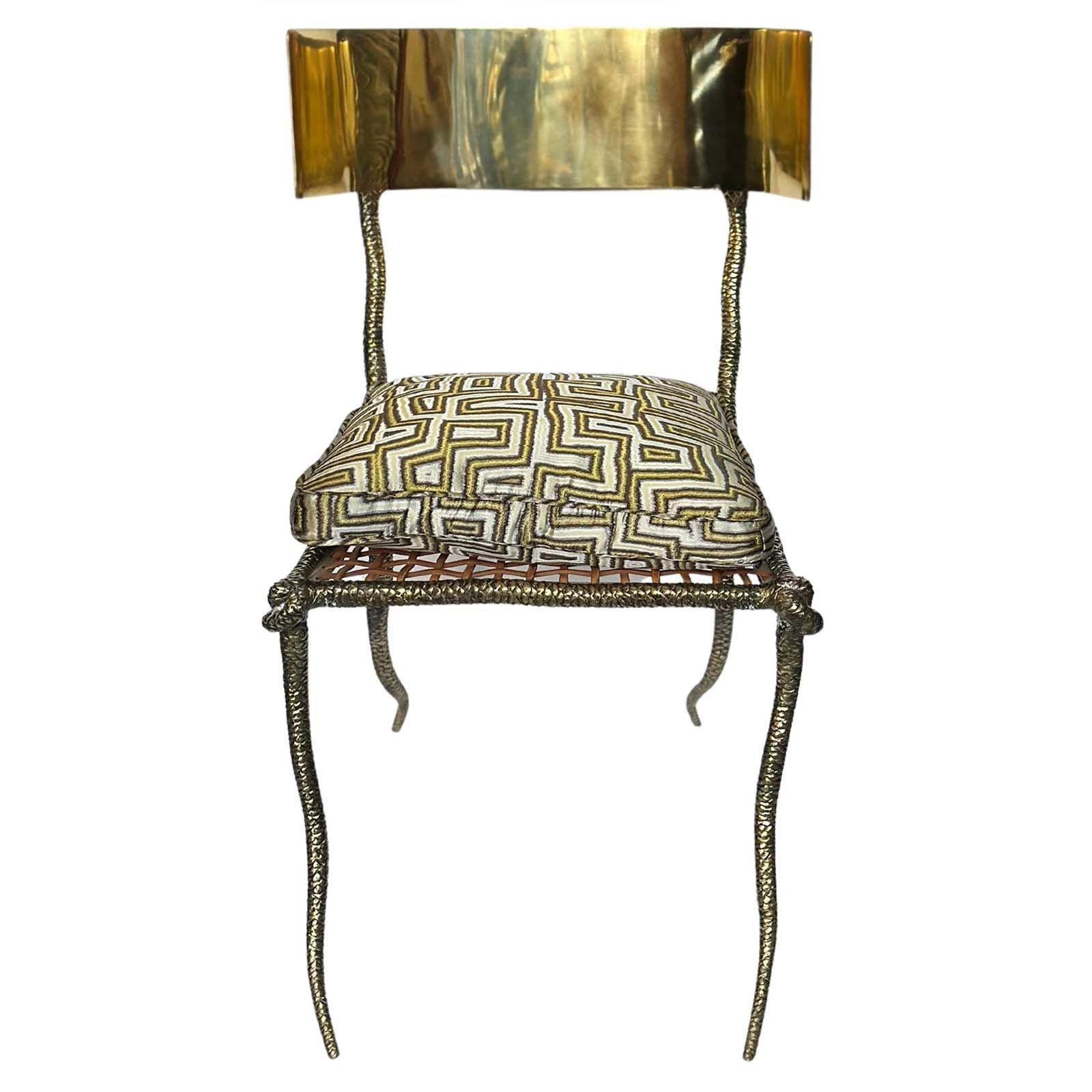 Pair of modern polished brass Klismos chairs with curved back, woven leather strapping and snake design on the brass work. Made in USA, 21st Century.
Each chair includes a removable cushion.
Dimensions:
35.5