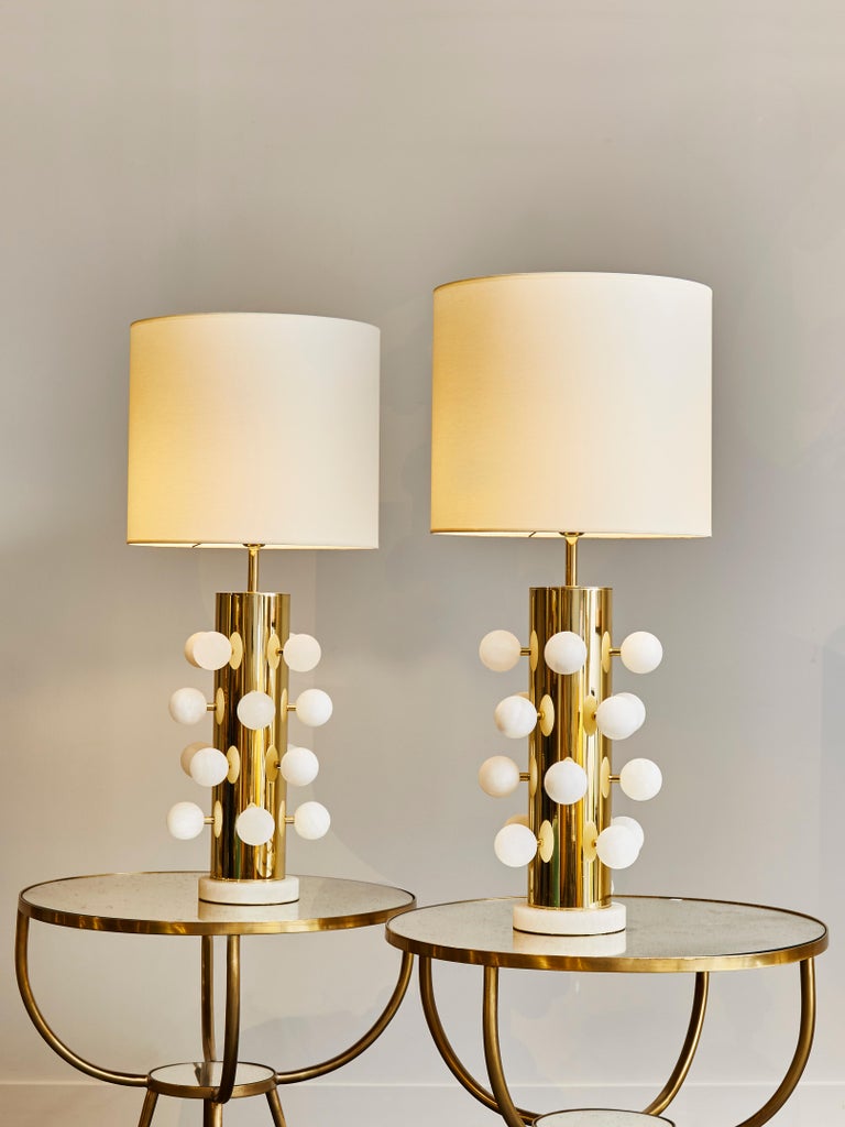 Pair of table lamps made of polished brass body, and alabaster feet and decorative spheres attached all over the lamps.
    