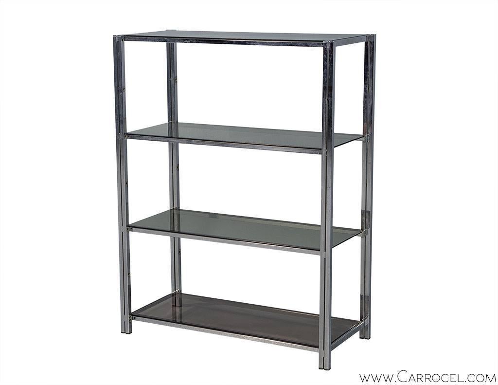 Pair of polished chrome bookcases. Modern designed with a squared tubular frame in polished chrome. Coming to approximately waist height the bookcases have four black smoked glass shelves, great for storage or display.

Price includes