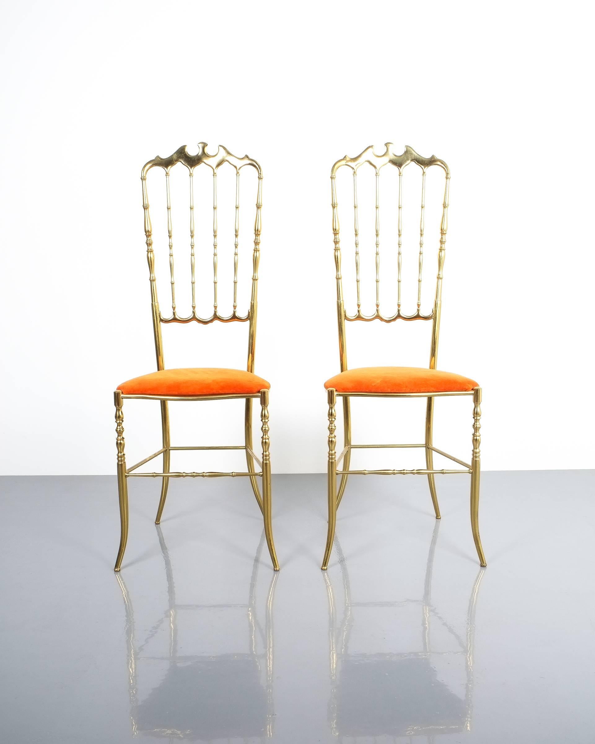 Beautiful pair of solid brass high back chairs by Chiavari, circa 1950. Both show a very nice golden patina and has got a orange-red velvet upholstery. The condition is very good.