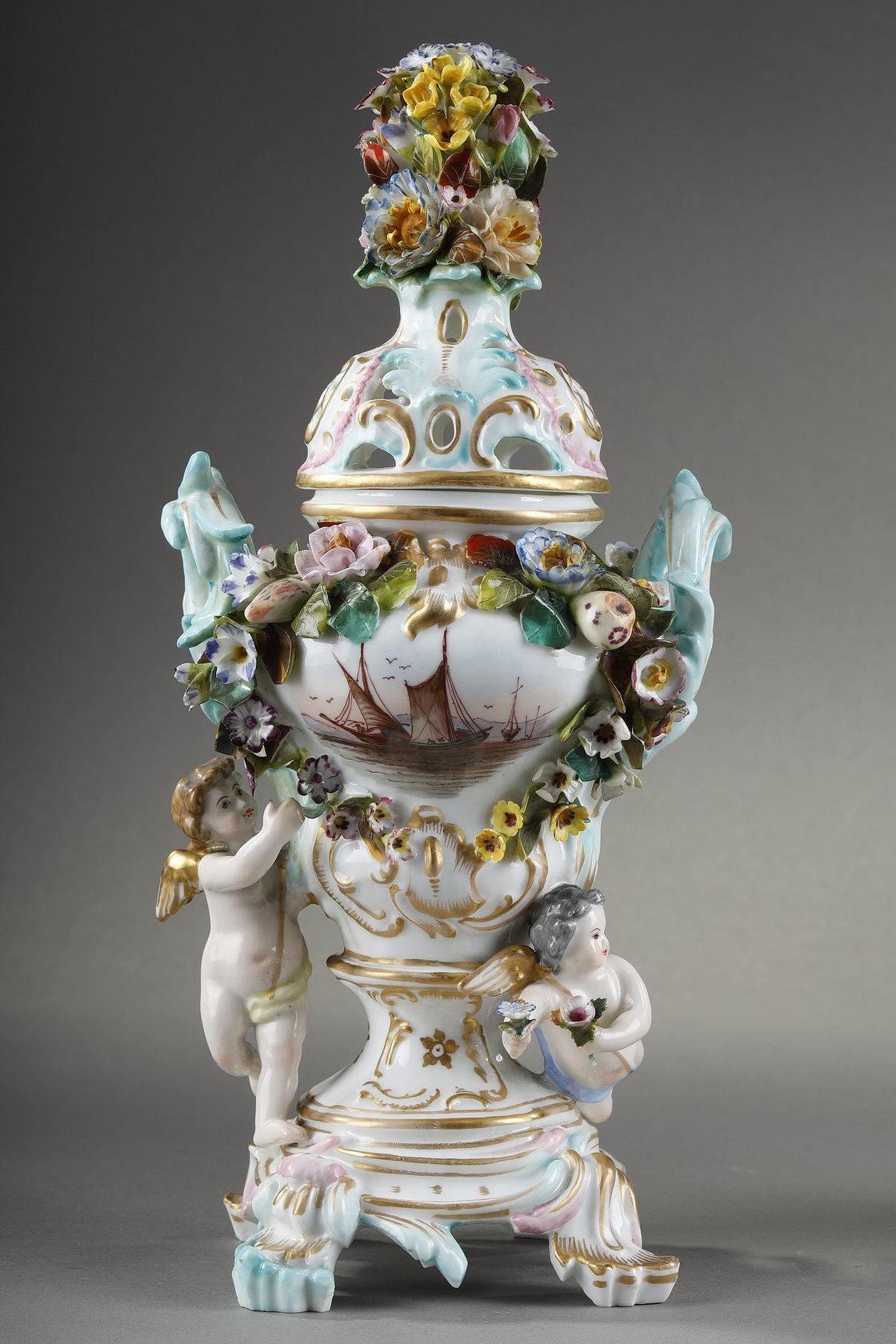 Pair of perfume burners in polychrome porcelain from the Meissen manufacture. They are crowned by removable openwork lids decorated with bouquets of flowers. Their bodies are decorated with flowers in relief forming cartouches in which are scenes