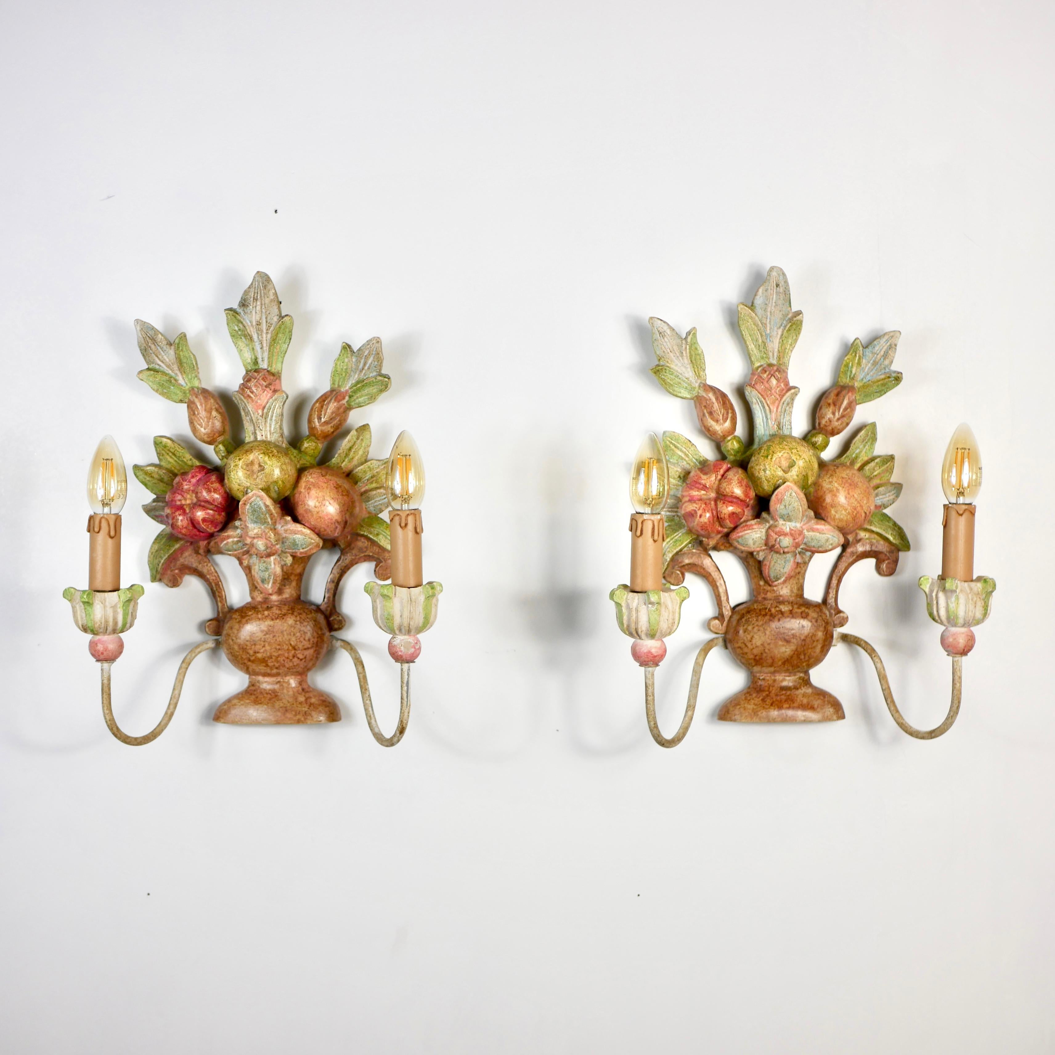 Beautiful pair of hand-carved wood sconces made in Italy in the early 20th century, depicting bunches / baskets of flowers, leaves and fruits, in the style of Maison Jansen.
Hand-painted, each sconce has two metal 