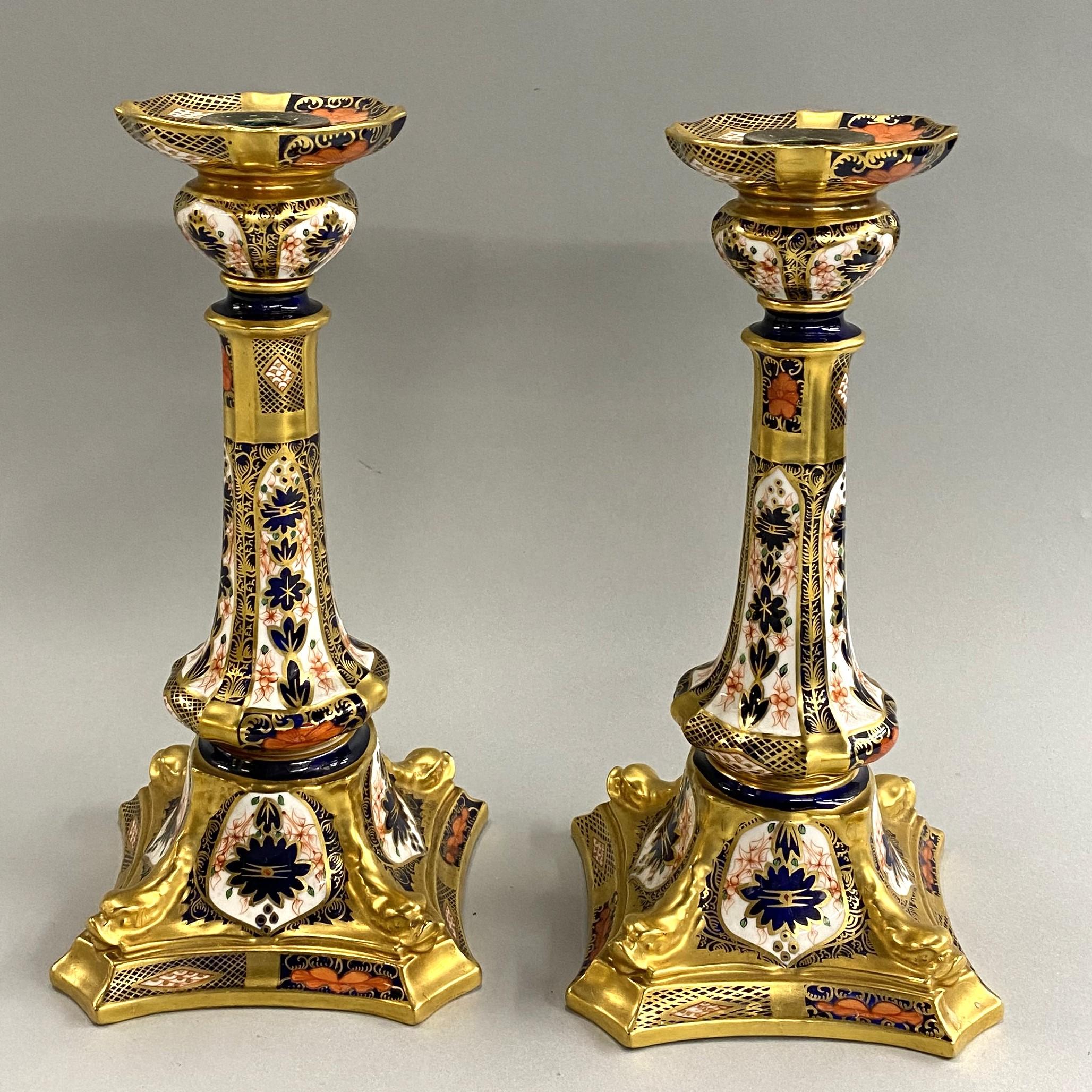 An exceptional pair of English polychrome porcelain or bone china Old Imari dolphin candlesticks by Royal Crown Derby, in blue, white, orange, and gilt highlights, signed on the underside, in very good overall condition, with minimal imperfections