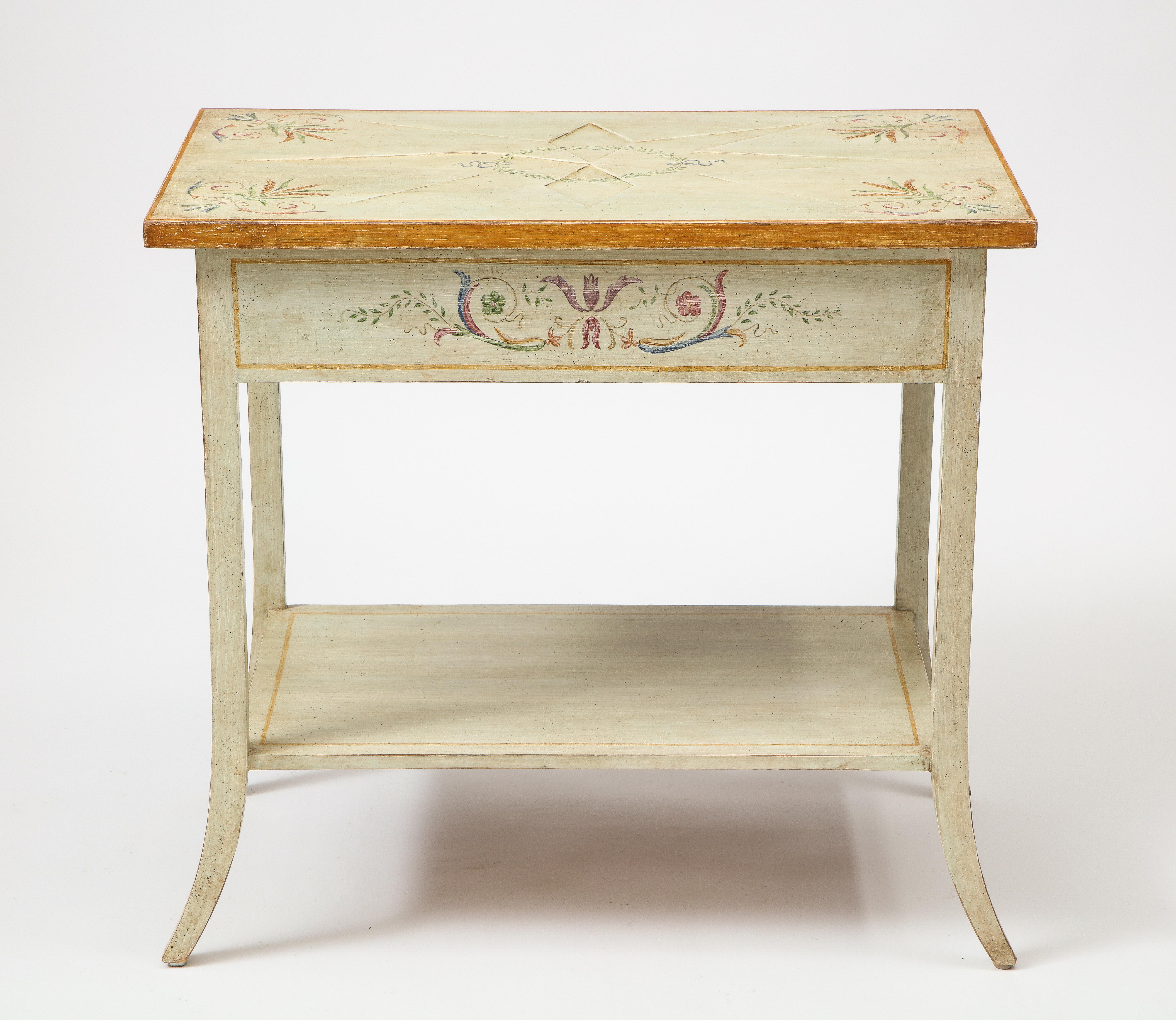 Pair of polychrome painted bedside tables of off-white / pale gray ground decorated with neoclassical bellflower garlands; the rectangular top centered by a recessed starburst and with gilt edge; fitted with one frieze drawer to the side; raised on