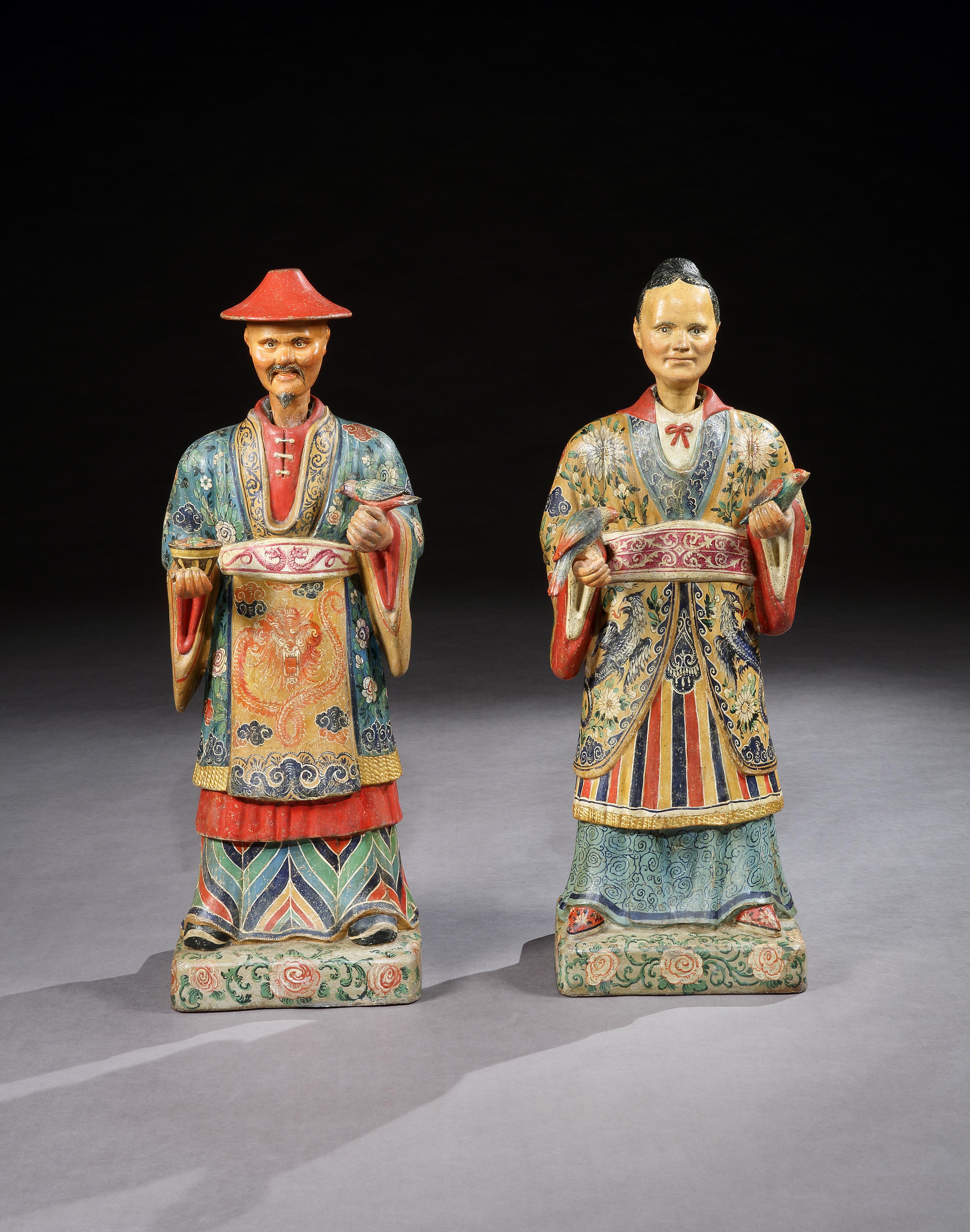 A rare pair of 19th century North Italian painted polychrome figures well modelled and decorated in brightly colored traditional garb.

The lady holding a bird in each hand, the man holding a bird and fruit filled basket, probably

depicting