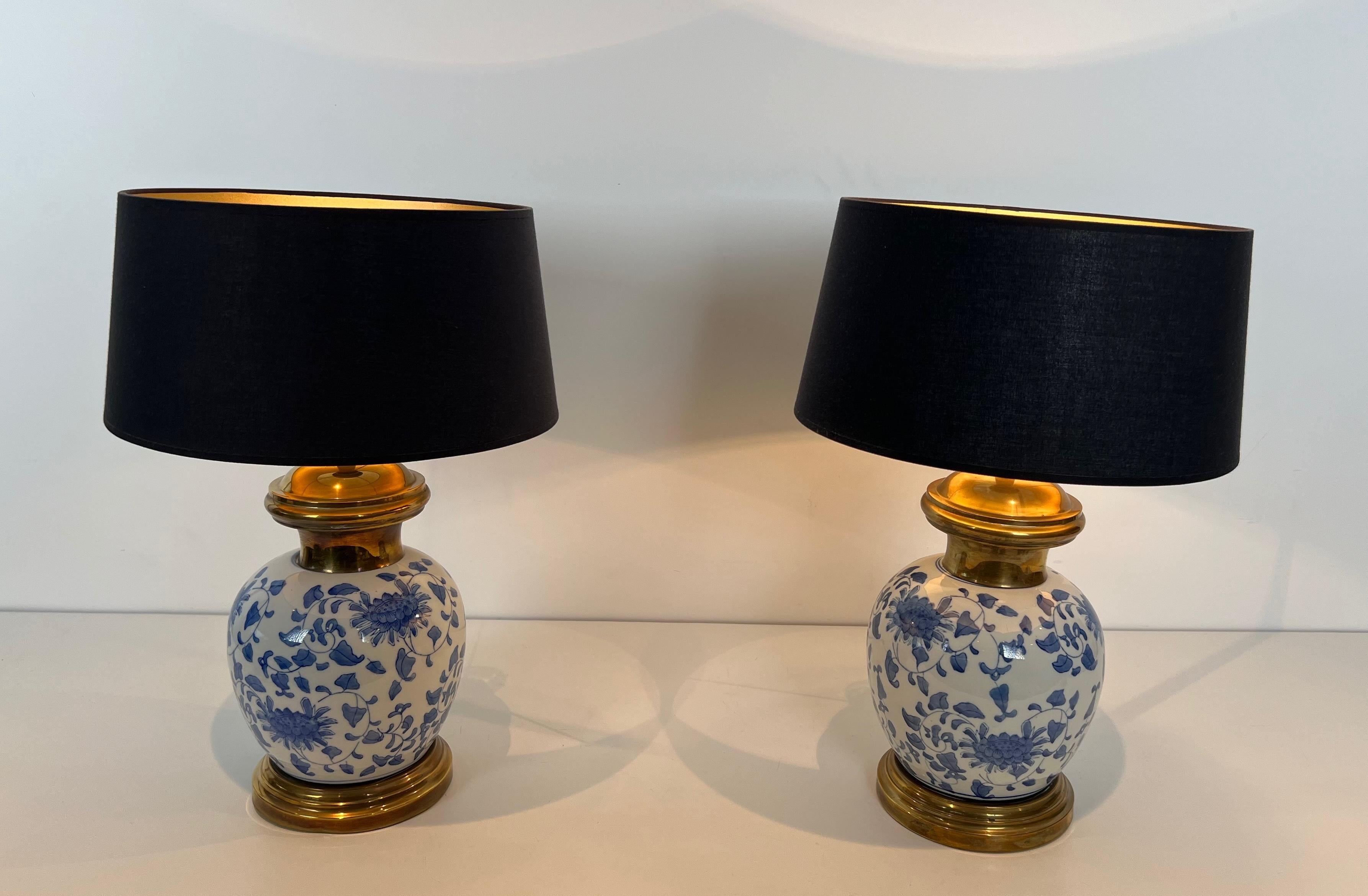 Questa bella e raffinata coppia di lampade da tavolo è realizzata in porcellana nei toni del blu e del bianco con decorazioni cinesi su una base in ottone. Questa è un'opera francese. Circa 1970