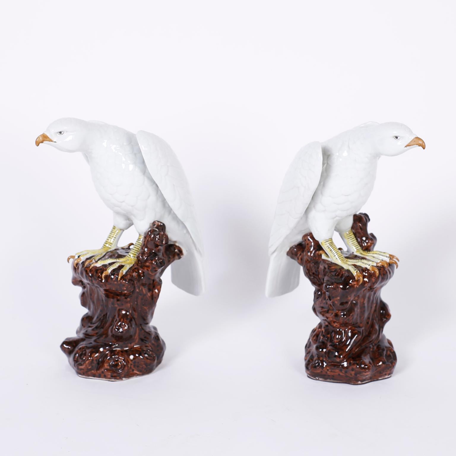 Pair of porcelain birds or white falcons with their confident attitude and formidable talons perched on faux tree trunks.