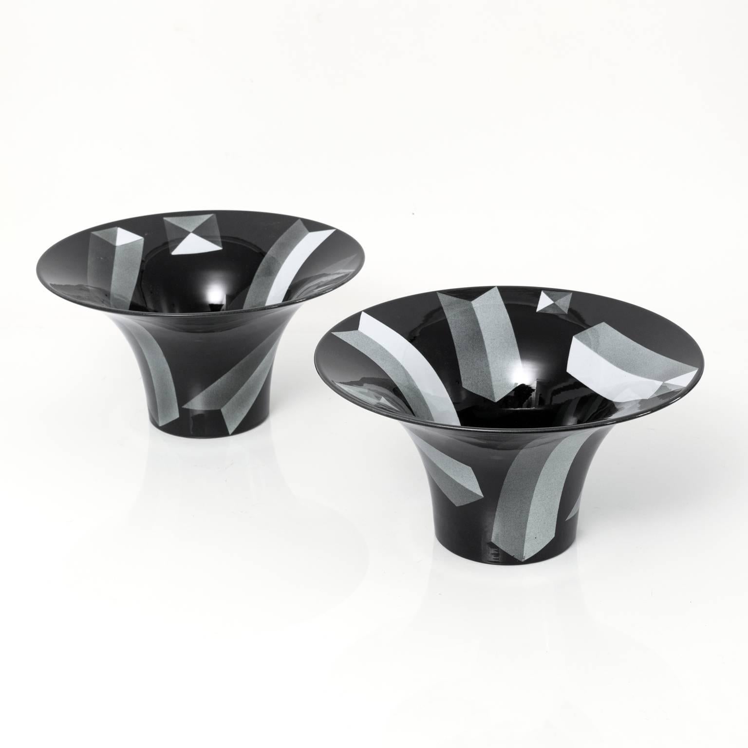 A matching pair of large beautiful Postmodern porcelain bowls by Rolf Sinnemark for Rörstrand, Sweden. The black glazed bowls are decorated on the exterior and interior with depictions of obelisk forms.

Measure: Height 6