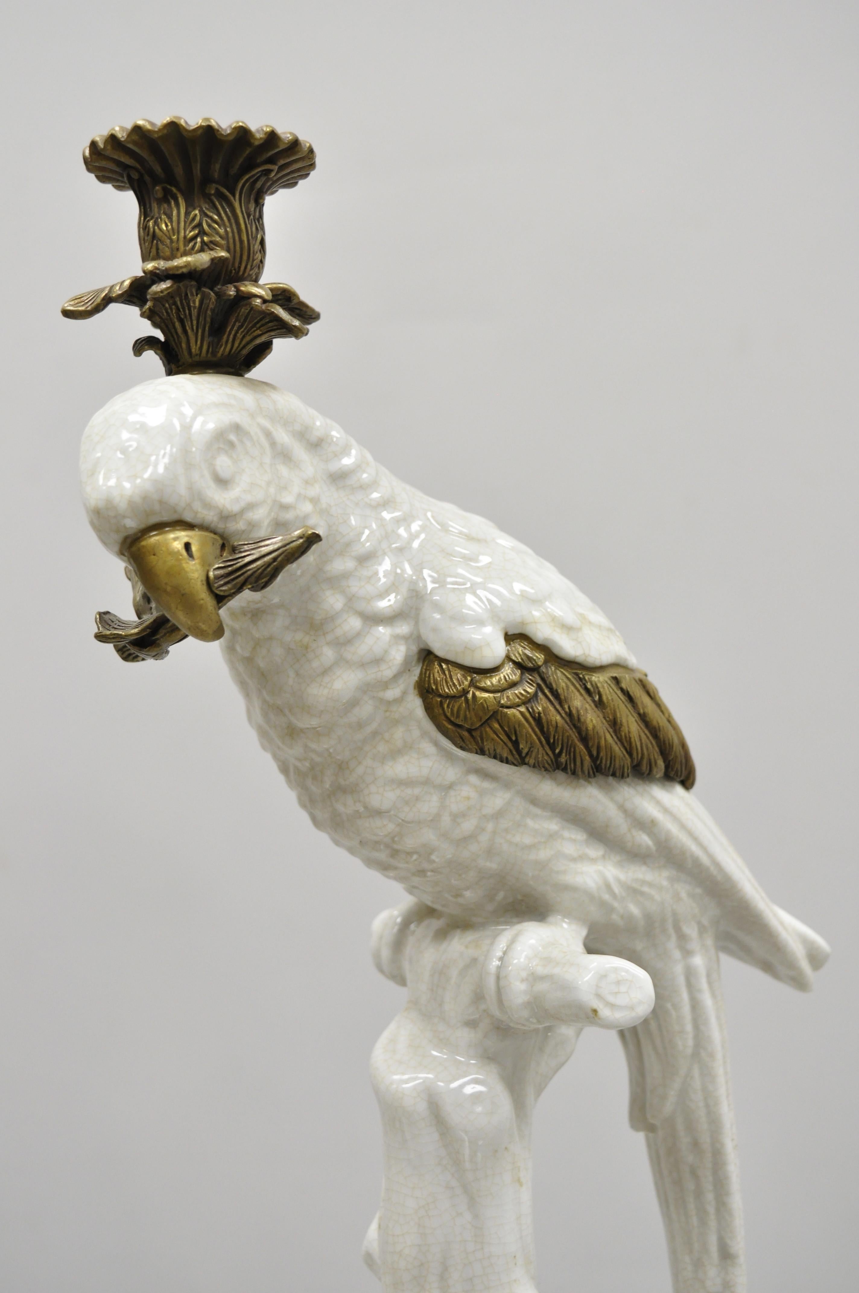 Pair of porcelain and bronze French style white parrot candlestick candle holders. Listing includes ornate brass base and ormolu, porcelain parrot figure, right and left form, circa late 20th century. Measurements: 14.5