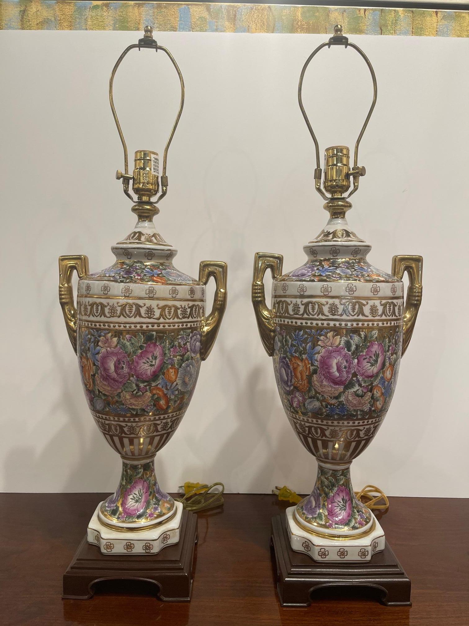 Pair of porcelain floral and gold trim vases with handles adapted as lamps, 20th Century.