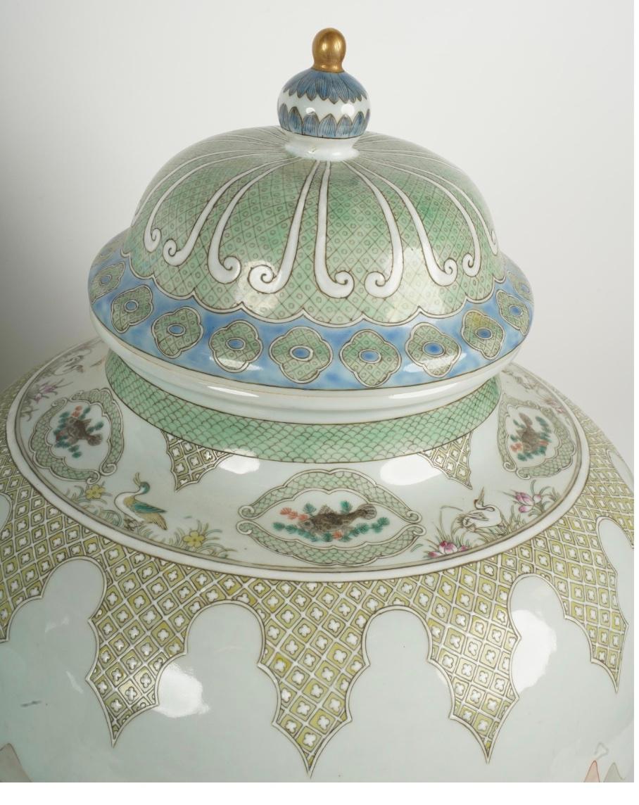 
Une belle paire de jarres en porcelaine avec couvercles, peintes à la main dans le style The JIANGS Cai.  Des nuances de bleu clair et de rouge brique se détachent sur un fond blanc cassé avec des nuances de vert représentant des scènes de jardin
