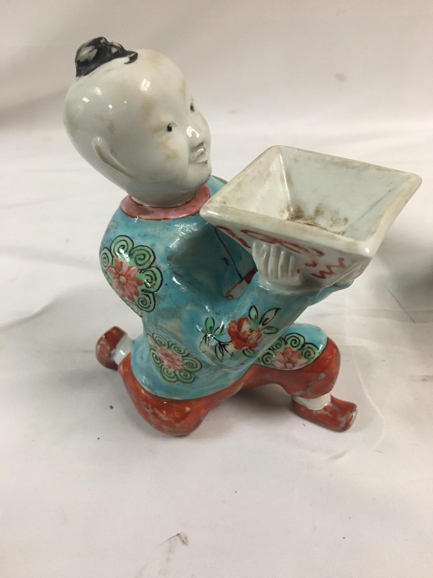 Hand-Painted Pair of Porcelain Kneeling Chinese Boys Holding Shallow Single Blossom Vessels For Sale