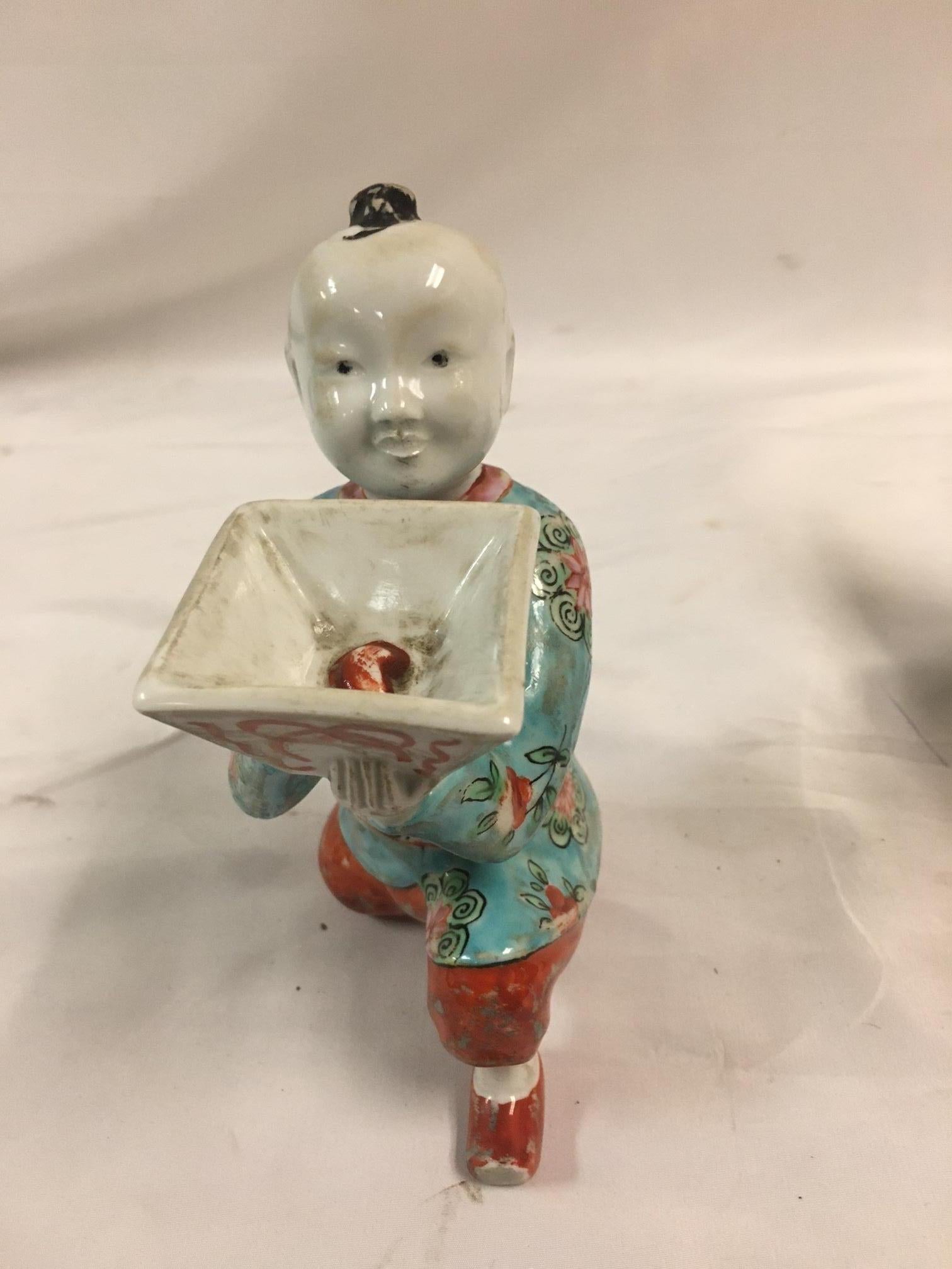 Pair of Porcelain Kneeling Chinese Boys Holding Shallow Single Blossom Vessels In Good Condition For Sale In Savannah, GA