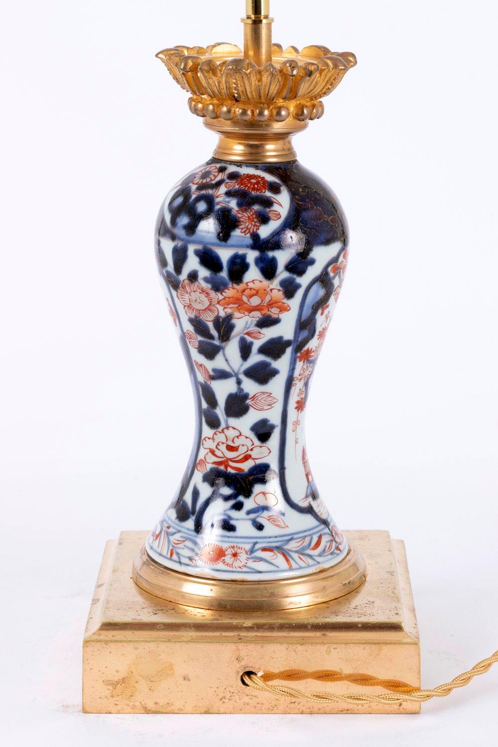 Pair of baluster shaped lamps in Imari porcelain. Chiselled and gilt bronze mount, standing on a moulded square shape base.
Lamp body bottom part decorated with a frieze of blue edgings framing chrysanthemum and red foliage. Floral Imari decor, blue