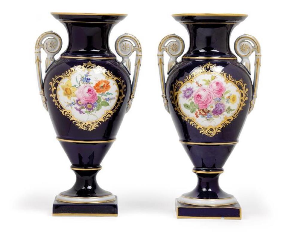 Pair of vases, porcelain, cobalt blue walls with fine and broad margins of gold, on the front a reserve with a colorfully painted bouquet on a white background, framed by golden leaves, white handles with golden edges, rosettes and leaves, round