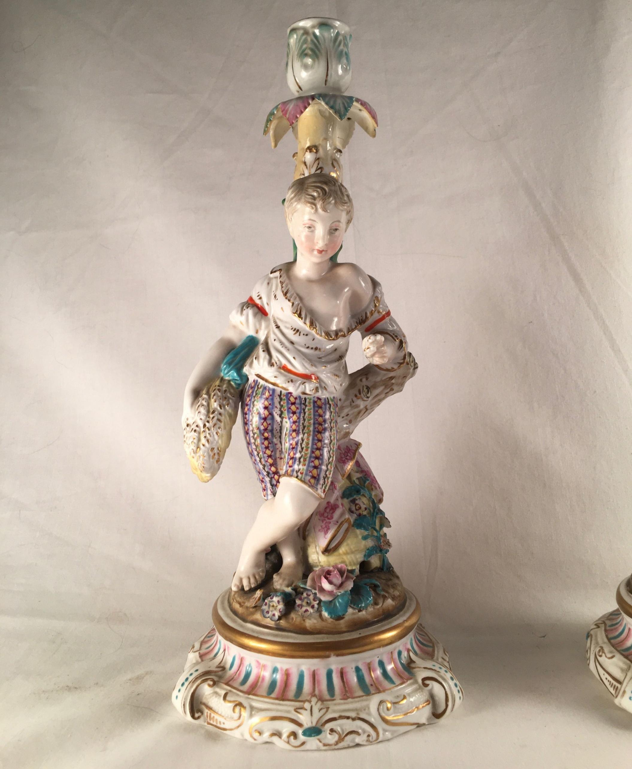 Pair of Porcelain Rococo style figural candlesticks ca. 1850

This pair of large and lovely candle holders is hand painted in exquisite detail and highlighted in gold. The enamel decoration has Meissen quality. The fine figures are rare and