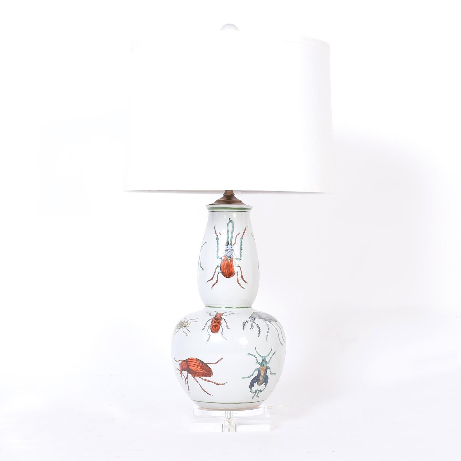 Pair of Chinese porcelain table lamps with classic form hand decorated with an assortment of colorful bugs or insects, presented on lucite double plinth bases.