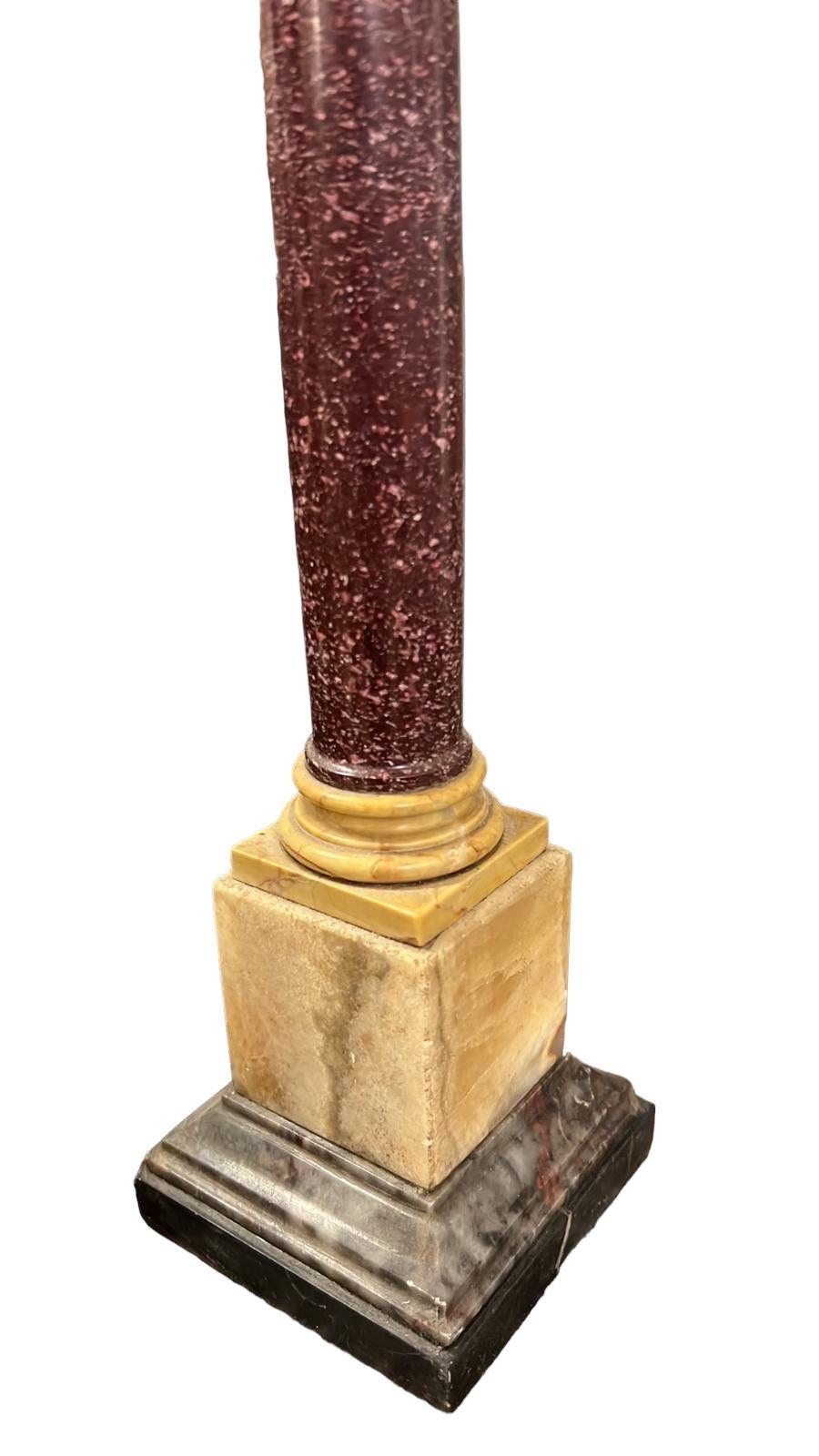 The grand tour porphyry columns with yellow marble Corinthian capitals and bases on black slate and gray Brescia ogee formed squares.
Measures: height: 16” base: 3 1/4” square.