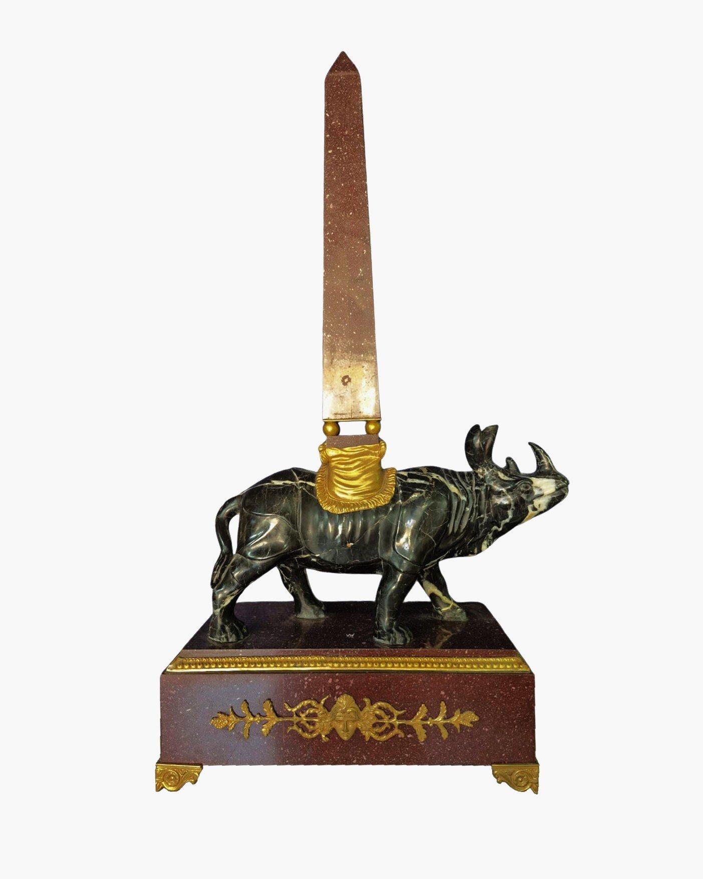Paire d'importants obélisques en porphyre, avec un rhinocéros en marbre noir et des décorations en bronze. 
DES PHOTOS SUPPLÉMENTAIRES, DES INFORMATIONS SUR LE LOT ET DES INFORMATIONS SUR L'EXPÉDITION PEUVENT ÊTRE DEMANDÉES EN ENVOYANT UN COURRIER