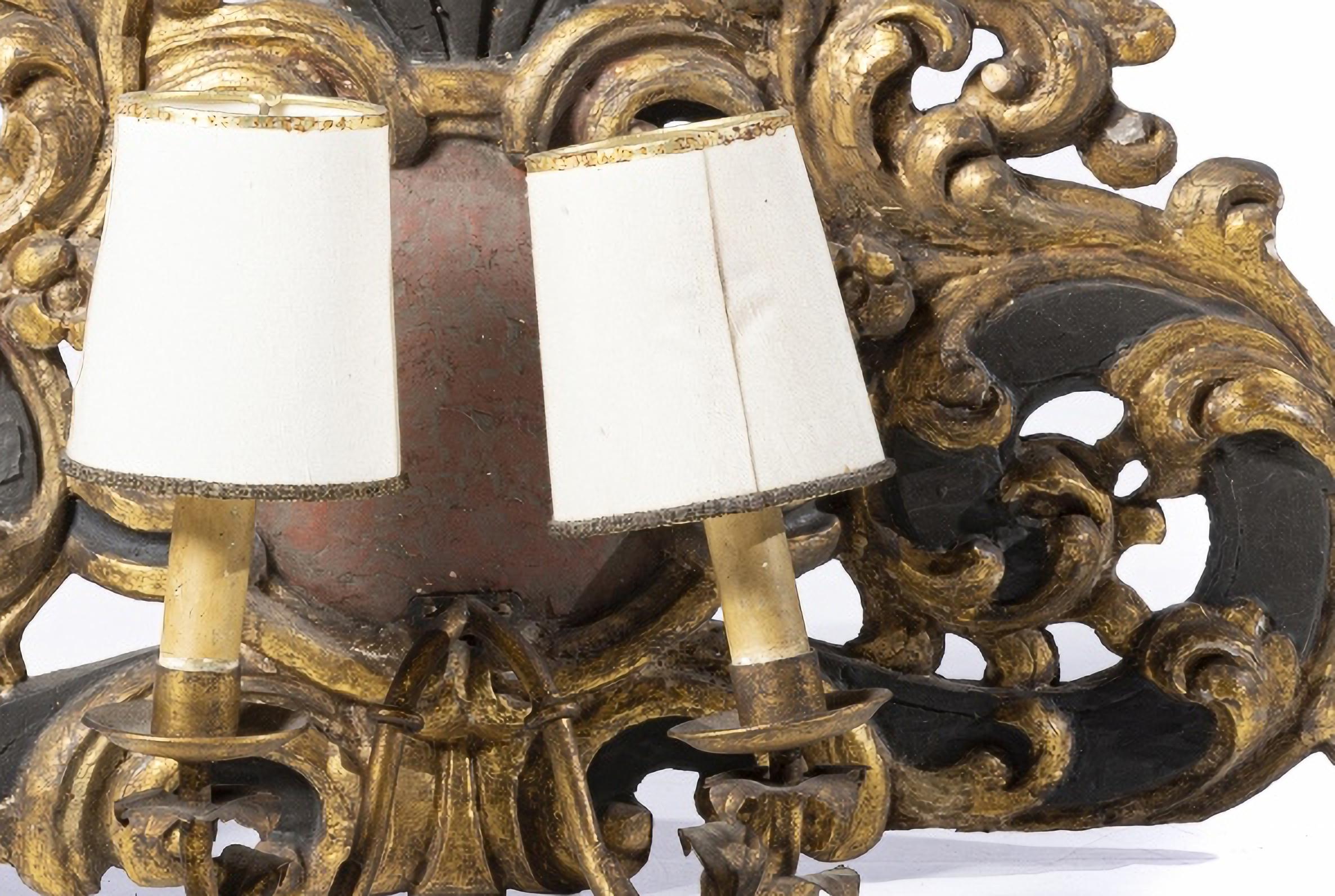 Paire d'appliques portugaises à deux lumières 18e siècle

refait à partir d'une sculpture peinte et dorée
décorées de motifs végétaux.
Applications métalliques.
Petits défauts.
Dimensions : 32 x 53 cm
de bonnes conditions.