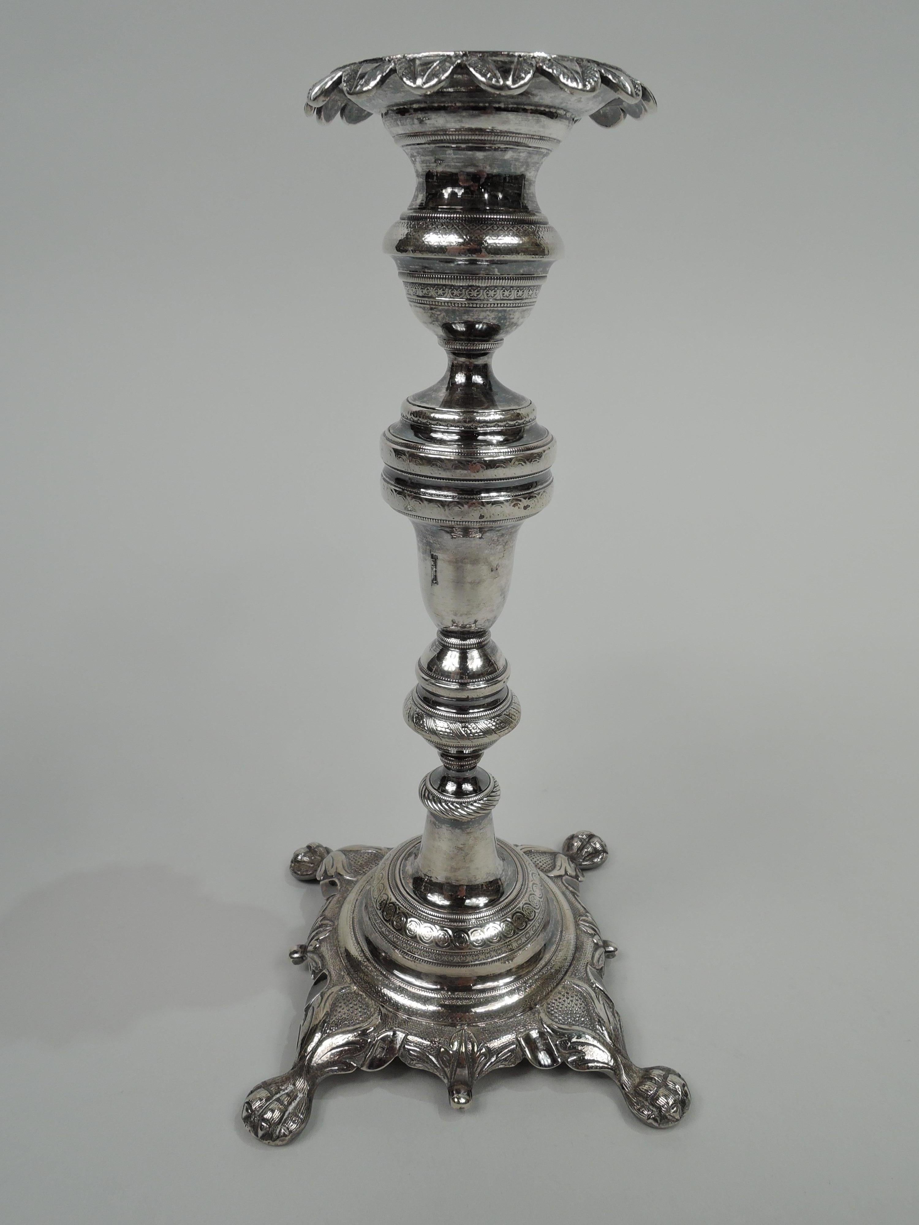 Pair of Portuguese Classical silver candlesticks, ca 1840. Each: Globular socket with turned downleaf-and-dart rim; knopped and baluster shaft on domed foot mounted to shaped square base with applied leaf rim and splayed corner paw supports. Dentil,