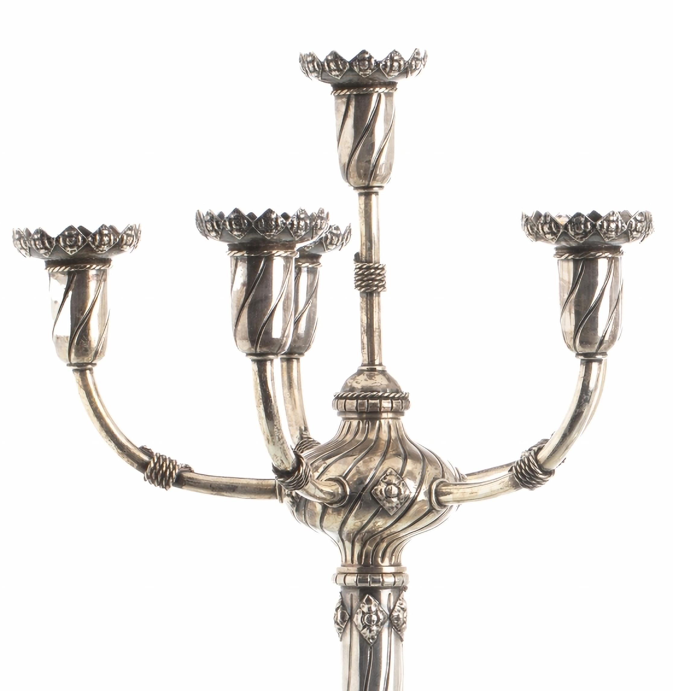 PAIR OF PORTUGUESE FIVE-LIGHT SILVER CANDLESTICKS 19th Century

Neo-Manueline-inspired work, decorated with windings, foliage, armillary spheres and Portuguese shields. With Lisbon contrast (Javali I), 1st title, 916 thousandths.
  Weight approx.: