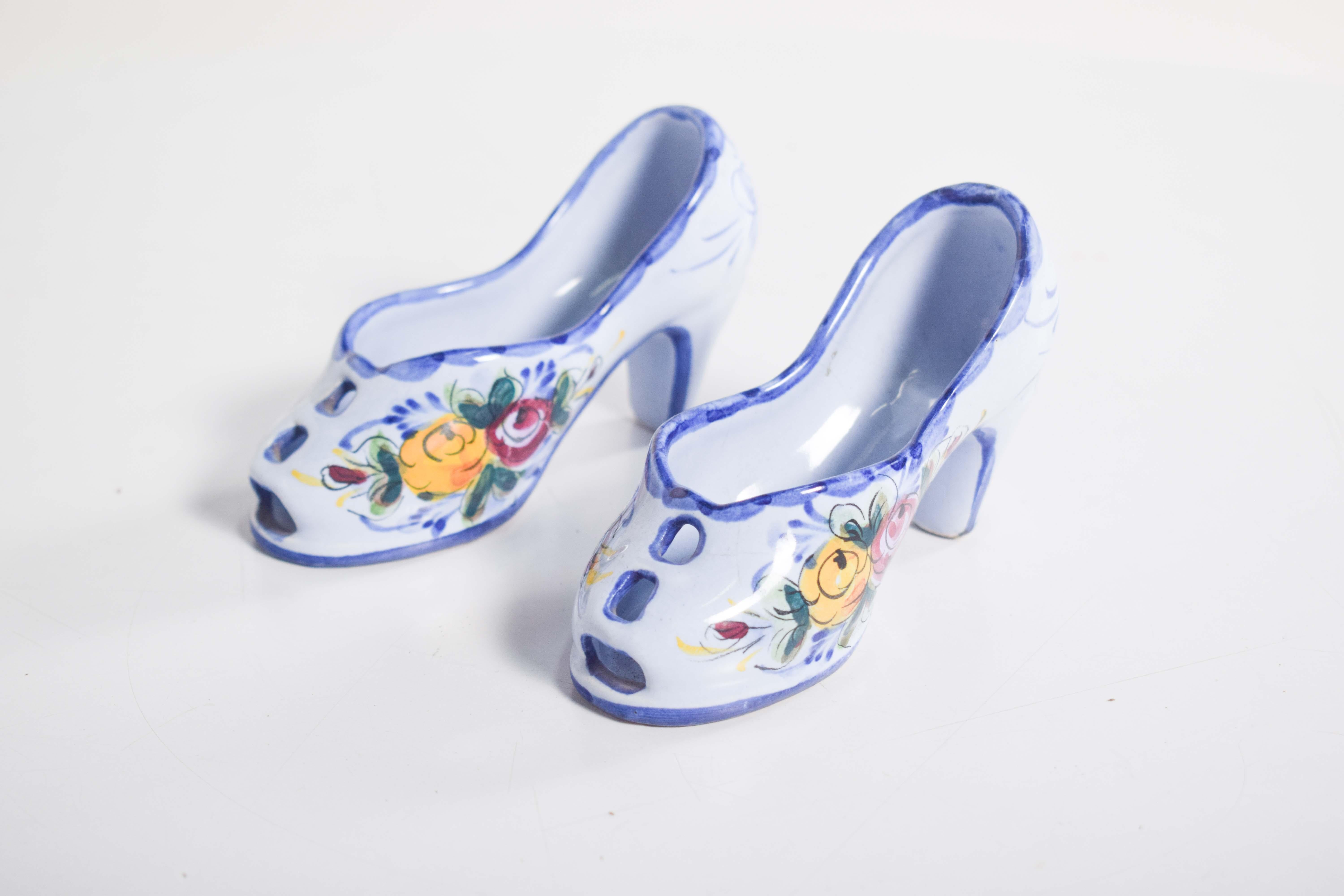 Questo affascinante paio di scarpe portoghesi in ceramica, realizzate nel rinomato stile Alcobaça - Vestal, mette in mostra la bellezza artigianale tipica della regione. Realizzate in ceramica smaltata di blu, queste scarpe in miniatura sono