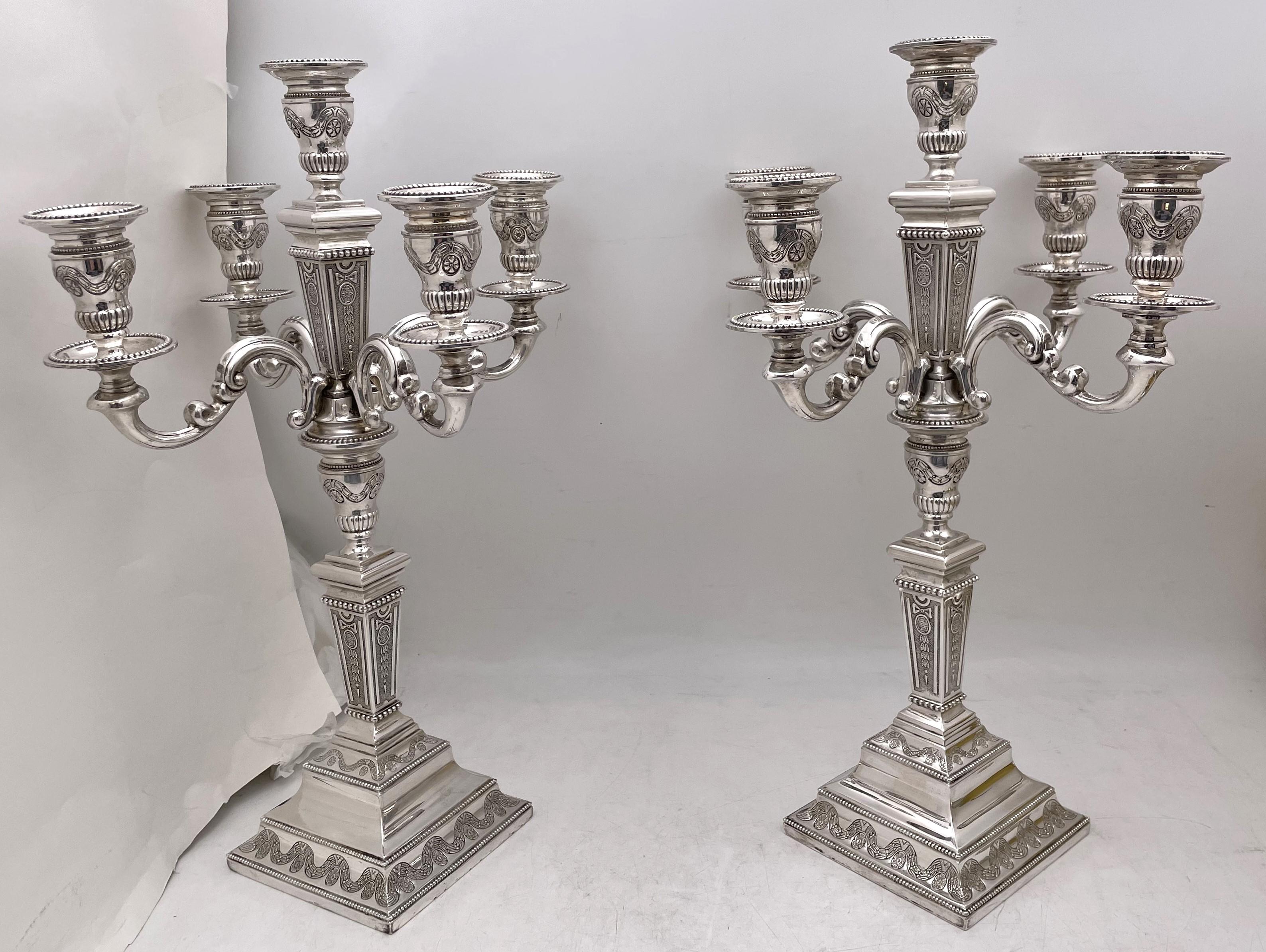 Pair of Portuguese 0.835 silver. 20th century pair of 5-light candelabra, beautifully adorned with floral, bows, and geometric motifs. They measure 16 1/3'' in height by 11'' arm to arm, weigh 76.3 troy ounces, and bear hallmarks as shown. 

Please