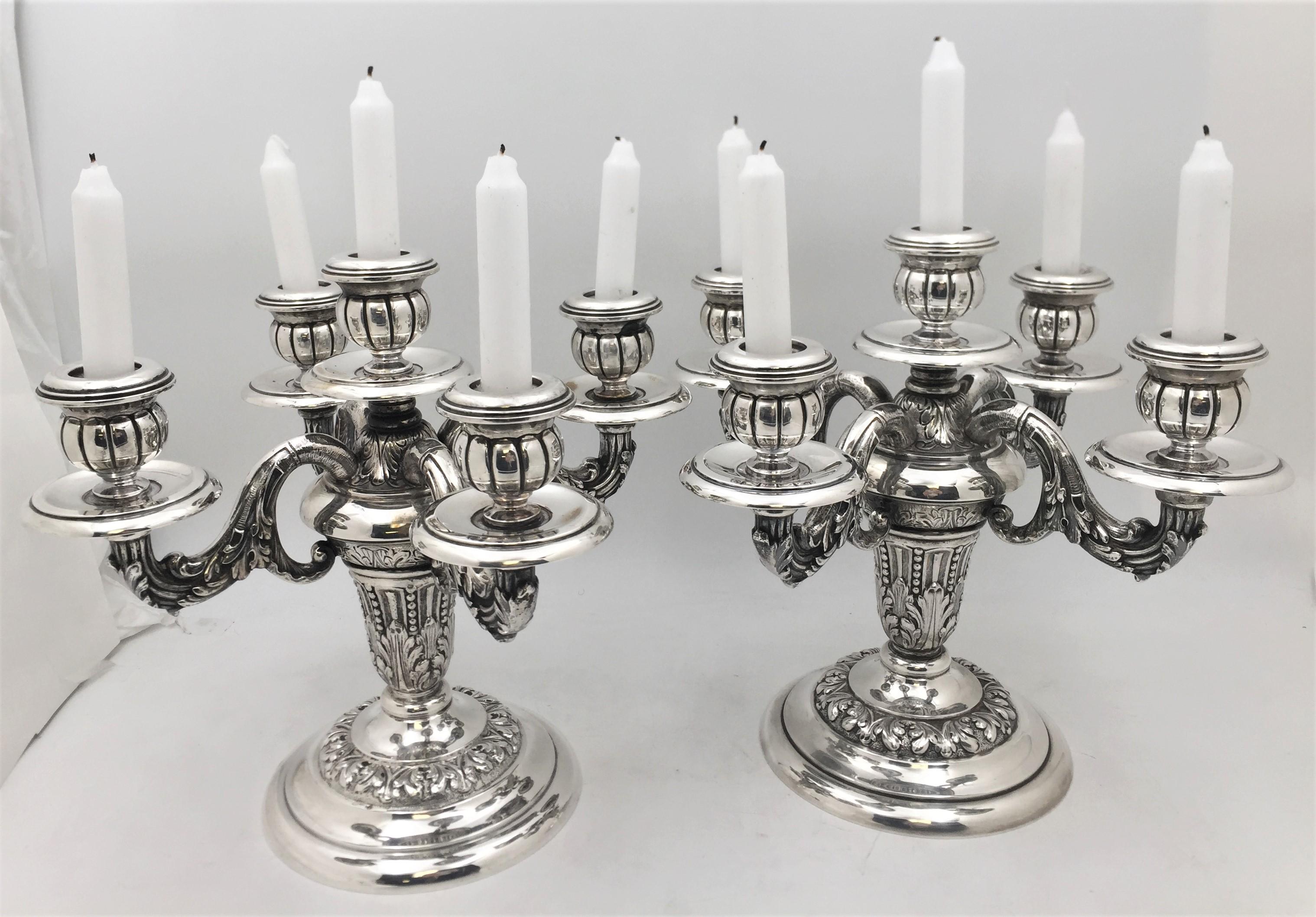 Pair of Portuguese silver, 5-light candelabra in an ornate style with leaves motifs across the body and the arms. These well-proportioned and elegant candelabra measure 11 1/3'' in height by 12 1/4'' from arm to arm. They are weighted but the