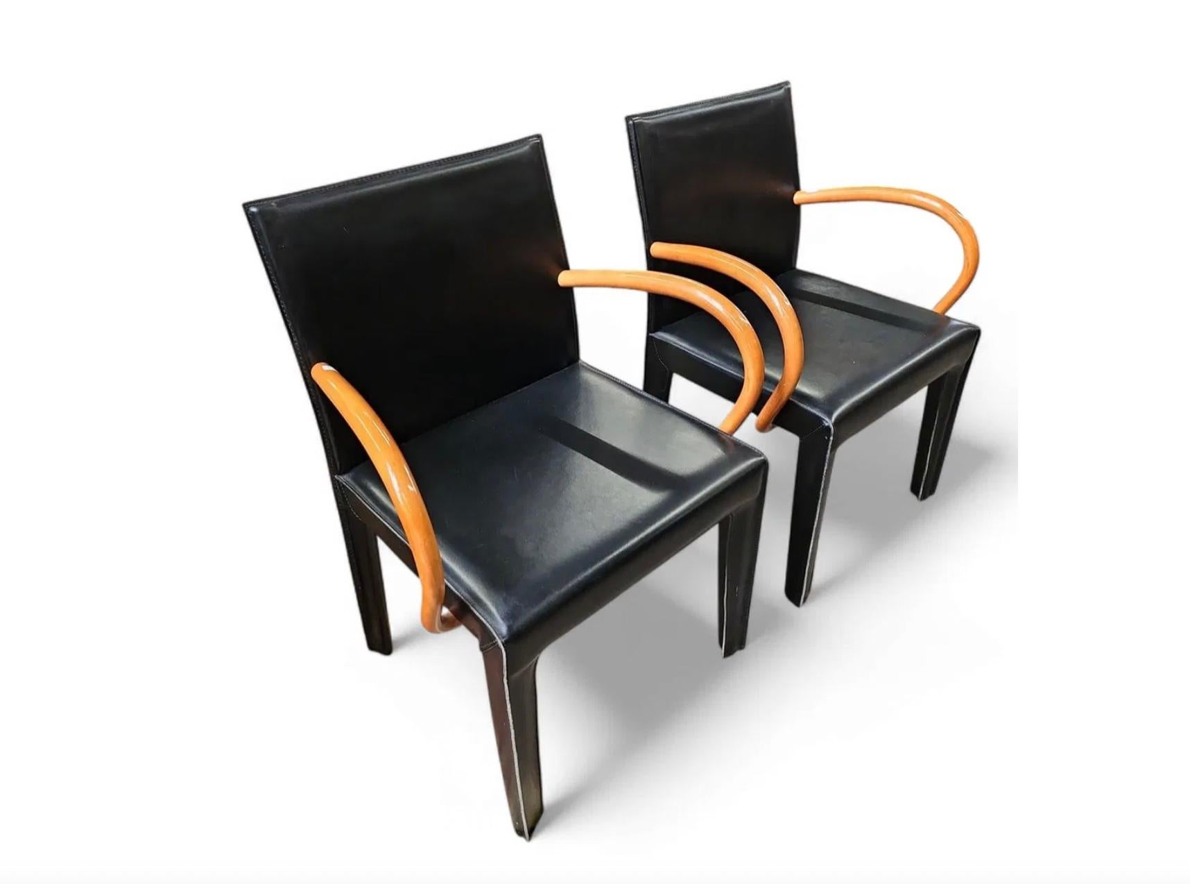 Una coppia di sedie da pranzo postmoderne di Arper sono completamente rivestite in pelle nera e hanno eleganti braccioli in legno curvato. Entrambe le sedie sono in ottime condizioni. Prodotto in Italia da Arper.

Venduto in coppia (2) Sedie

Ogni