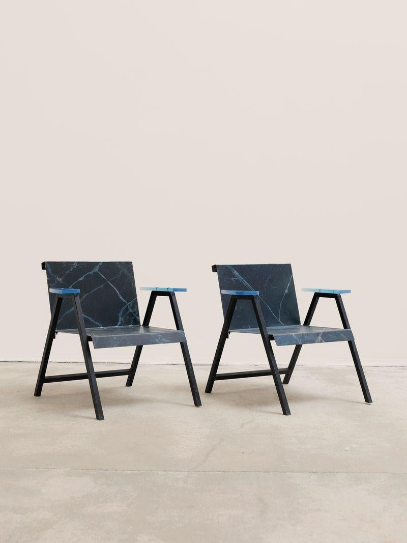Pair of post-modern chairs in metal and resin, French production, circa 1980. 

This pair of armchairs has an imposing appearance and is composed of geometric shapes drawn on different surfaces, thus revealing several perspectives. 

