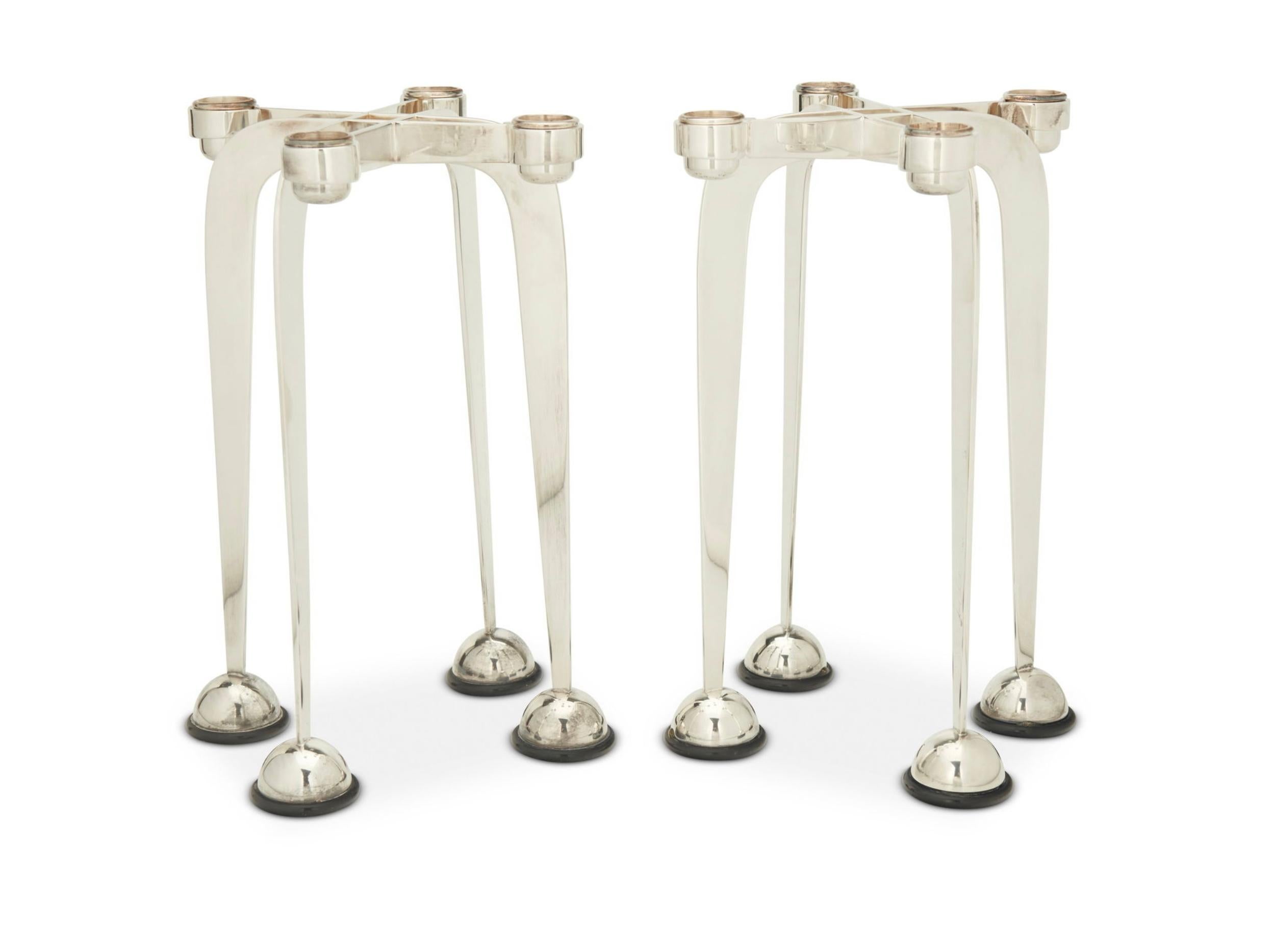 Una bellissima coppia di candelieri postmoderni in argento placcato di Lino Sabattini, appartenenti alla serie Harmony del 1989/90. Sono contrassegnati sul lato di un montante.  Un design elegante e insolito da trovare intatto. 
Come per tutte le