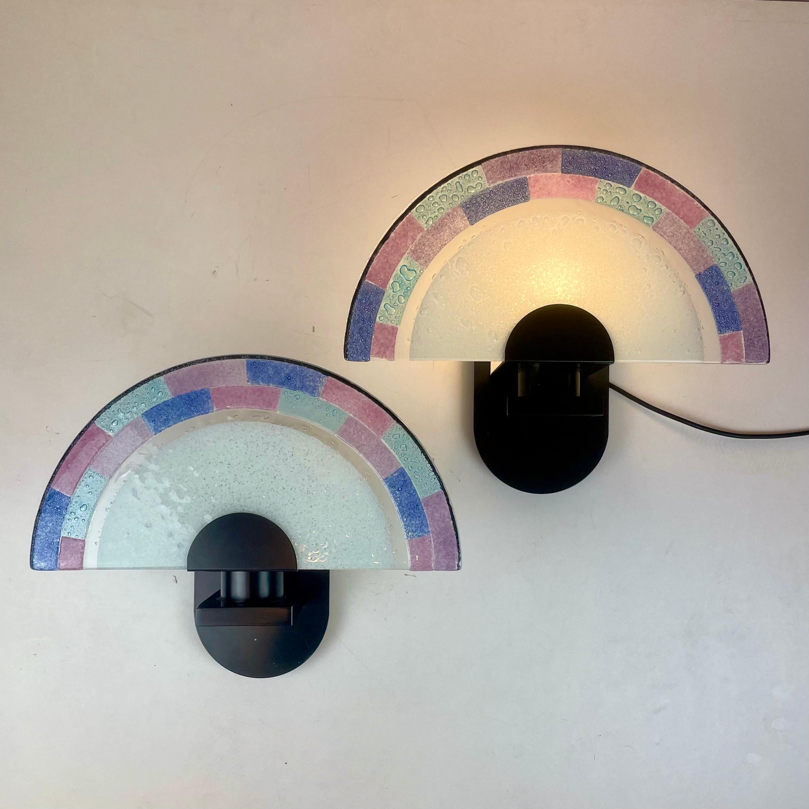Pareja de apliques de pared postmodernos italianos de cristal de Murano con textura azul y rosa en forma de abanico sobre una base redondeada de metal negro, diseñados por Zonca en la década de 1980.
Combina bien con esta lámpara de sobremesa: Gran