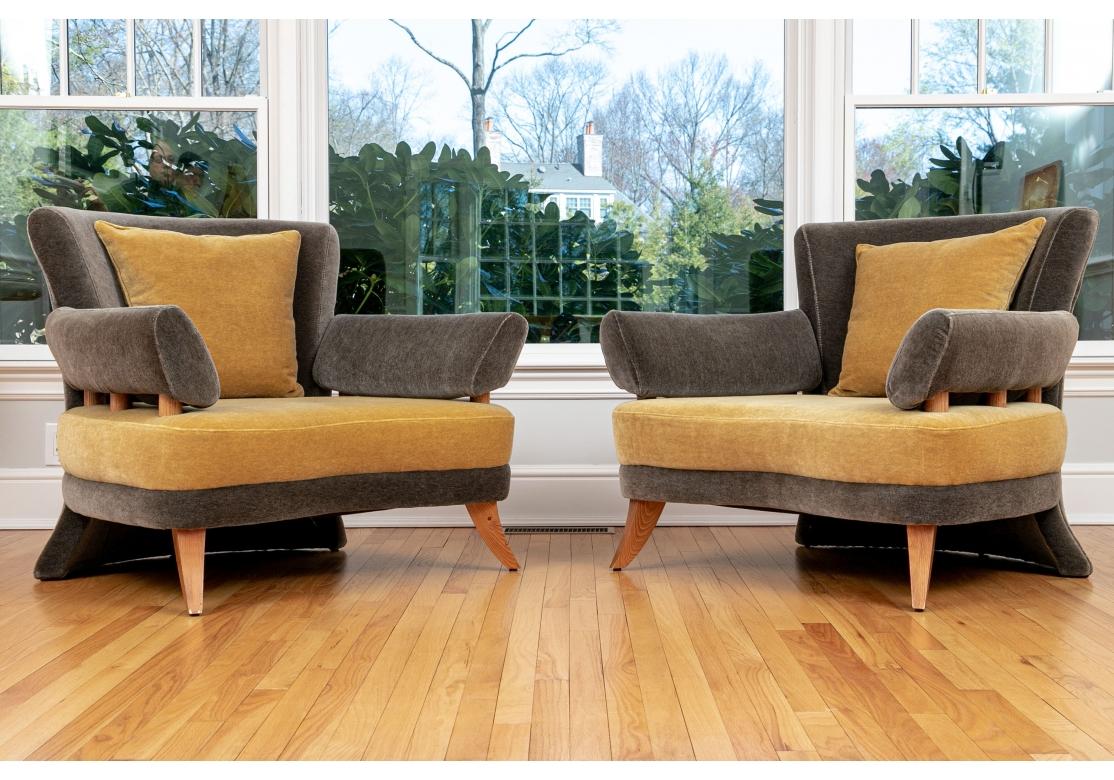 A pair of Post Modern style Mohair Lounge chairs in contrasting Mustard and Grey. The serpentine form lounge chair with fixed back and unusual back leg that flows from the top to the bottom and nearly the full width of the chair. The wedge form arms